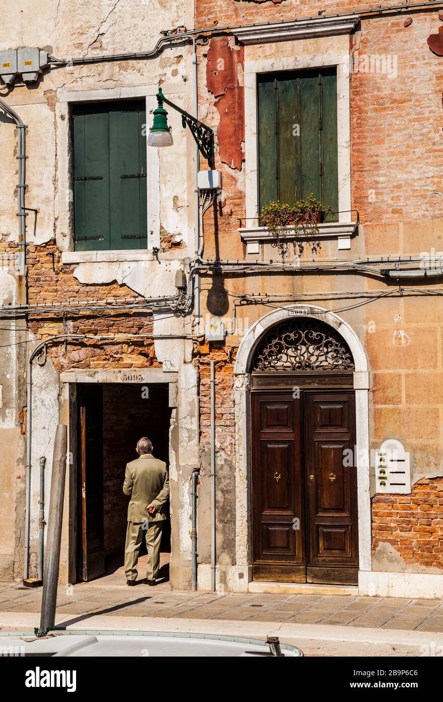 Domenica mattina uomo in una porta, Venezia, Italia. Foto Stock
