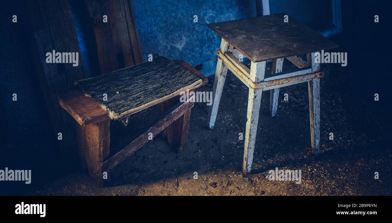 Due vecchie sedie di legno basso nella chiosetta del fienile scuro. Foto Stock