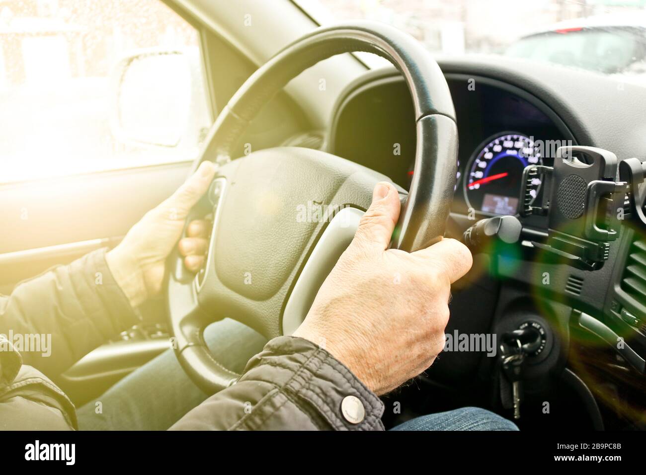 Le mani degli uomini sul volante di un'auto. Il conducente controlla la vettura. Foto Stock