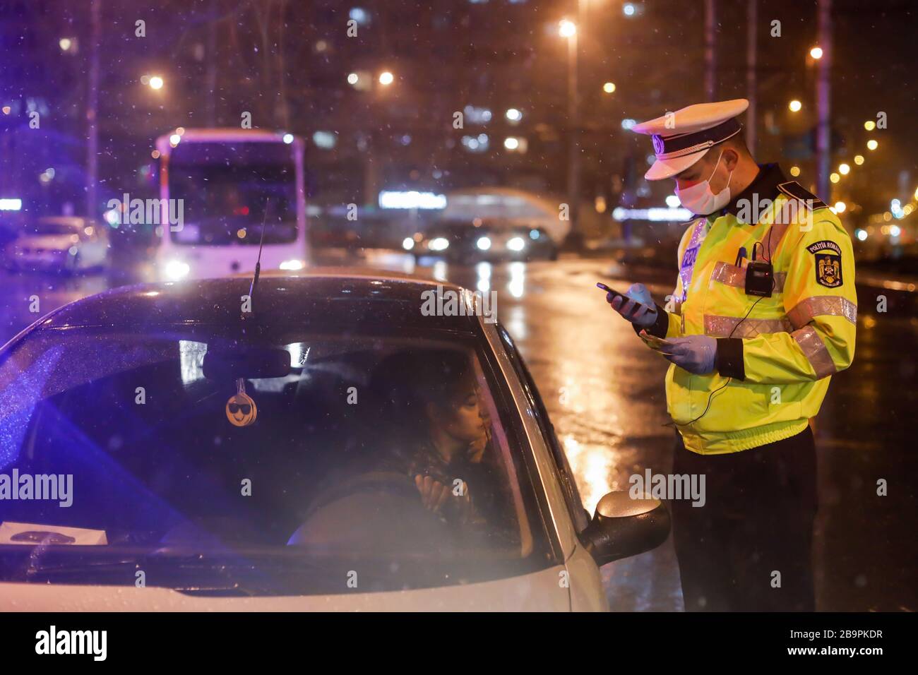 Bucarest, Romania - 23 marzo 2020: La polizia controlla i piloti e le loro carte durante il coprifuoco nelle strade di Bucarest in mezzo alla diffusione del CO Foto Stock