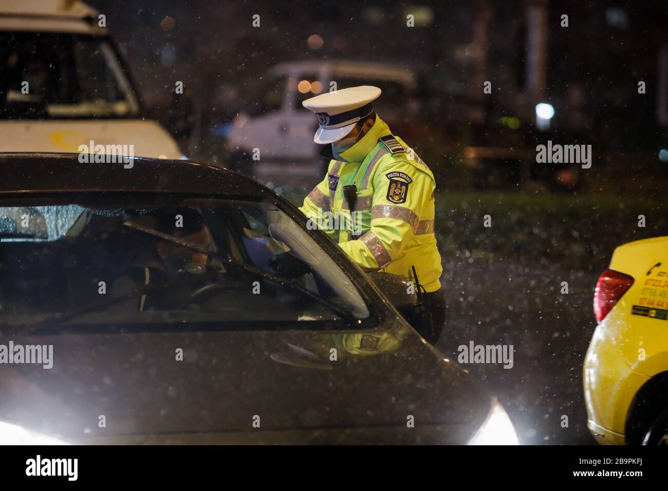 Bucarest, Romania - 23 marzo 2020: La polizia controlla i piloti e le loro carte durante il coprifuoco nelle strade di Bucarest in mezzo alla diffusione del CO Foto Stock