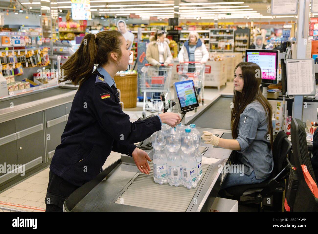 Wilhelmshaven, Germania. 24 Marzo 2020. Il caporale Eileen Barein (l) della base navale fa shopping in un supermercato. Durante la crisi di Corona, i soldati della marina della più grande base militare tedesca di Wilhelmshaven aiutano gli anziani a fare shopping. Credit: Martin Remmers/dpa/Alamy Live News Foto Stock