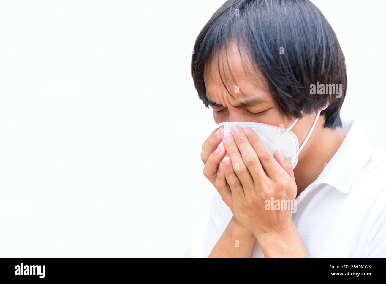 Un uomo asiatico indossa maschera N95 e tosse azione Foto Stock