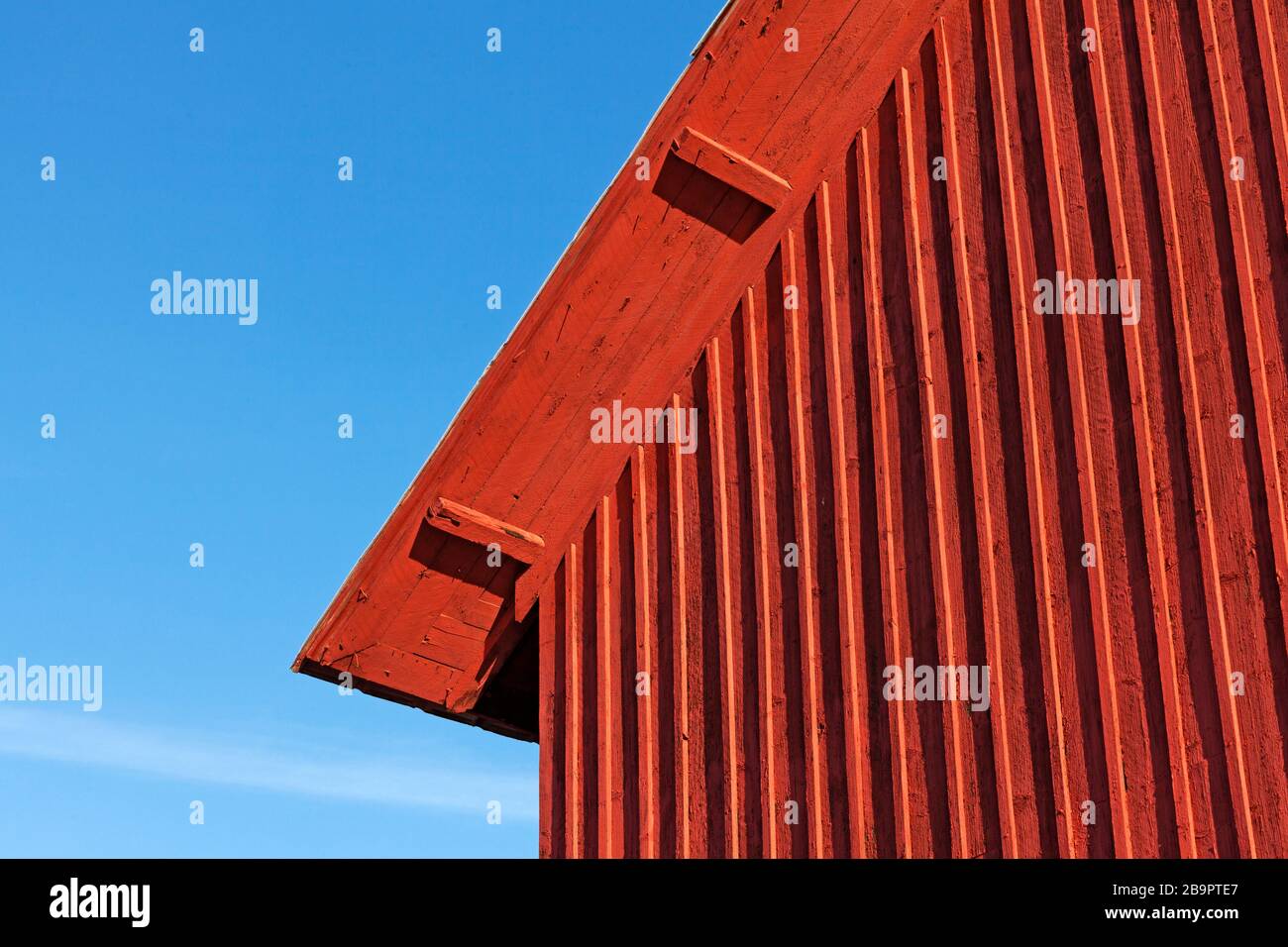 parte di una vecchia casa colonica, un tetto rosso contro un cielo blu Foto Stock