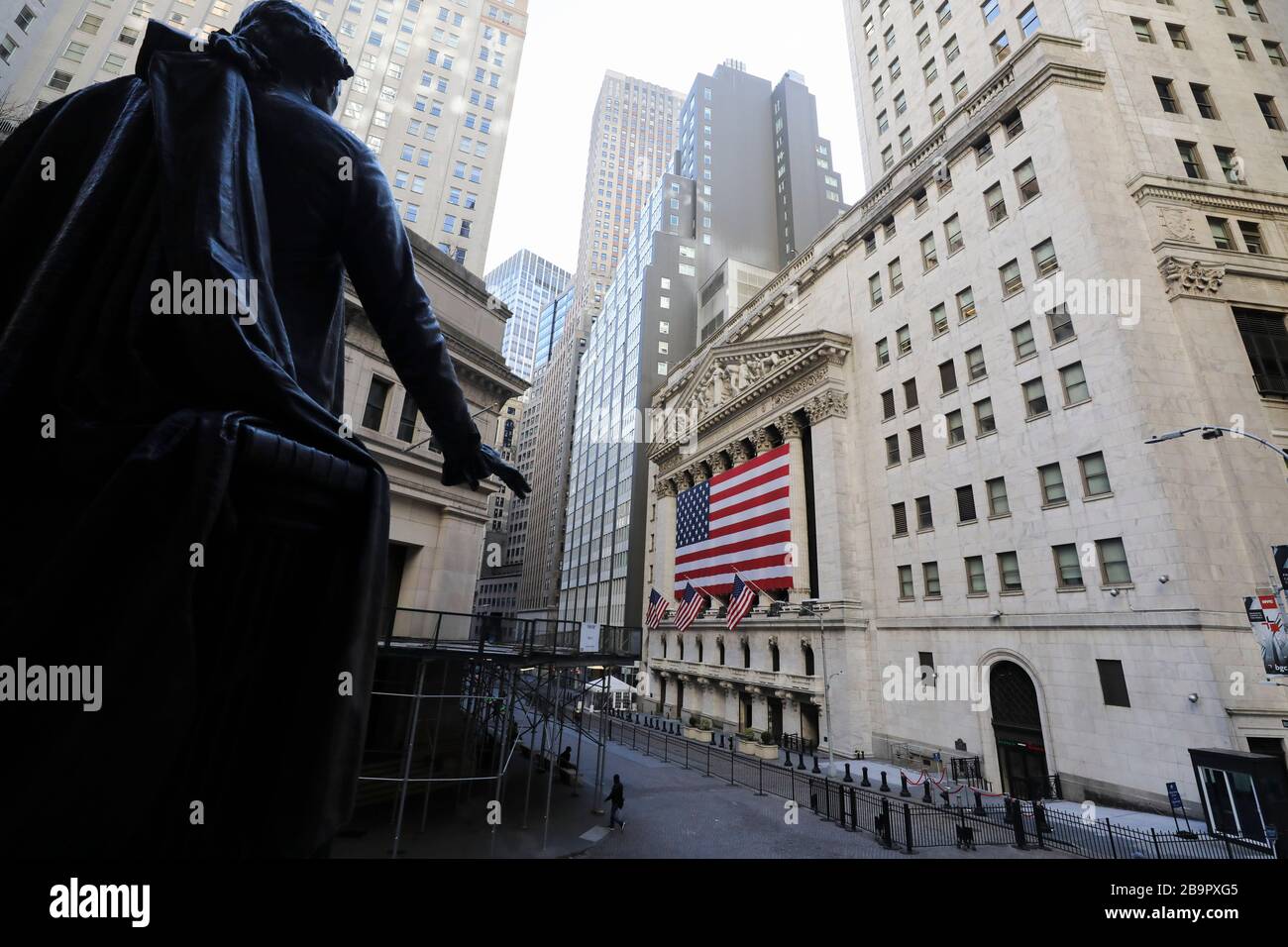 New York, Stati Uniti. 24 Marzo 2020. La foto scattata il 24 marzo 2020 mostra la Borsa di New York e la statua di George Washington a Wall Street a New York, negli Stati Uniti. Gli stock degli Stati Uniti hanno chiuso bruscamente più alto il martedì con il Dow su più di 11 per cento, notching il relativo guadagno più grande di una-giornata percentuale dal 1933 fra le speranze di stimolo. Credit: Wang Ying/Xinhua/Alamy Live News Foto Stock
