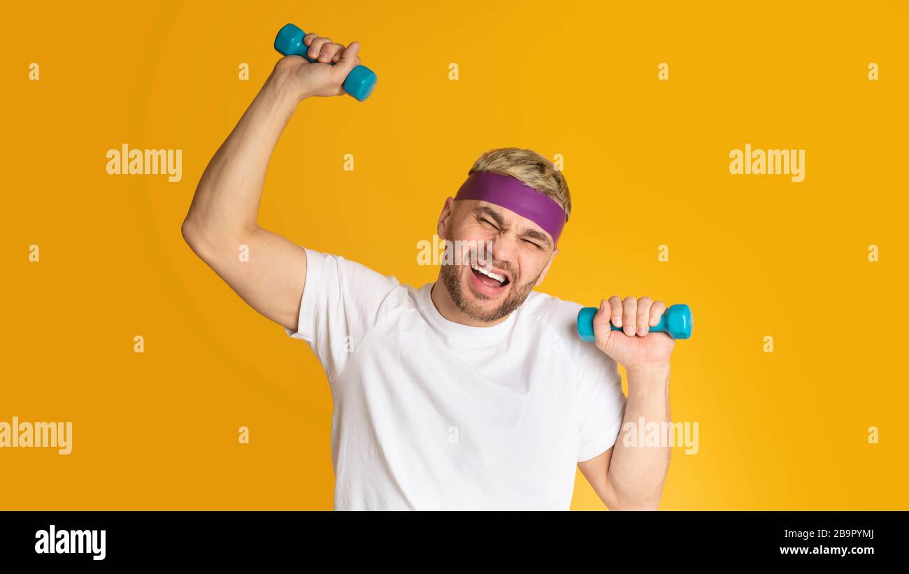 Uomo divertente difficile fare esercizi con manubri Foto Stock