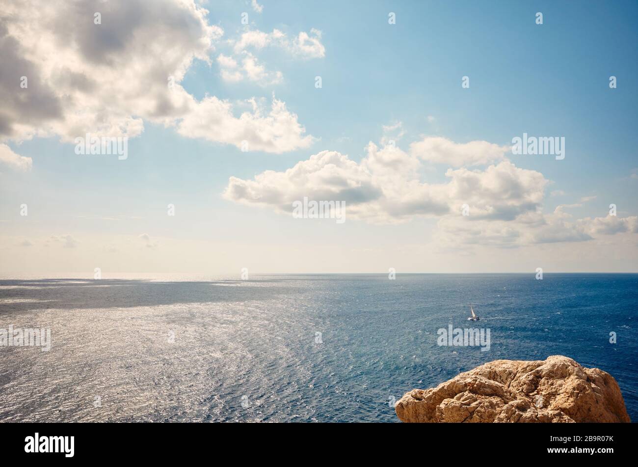 Paesaggio marino con una roccia in primo piano in una giornata di sole. Foto Stock