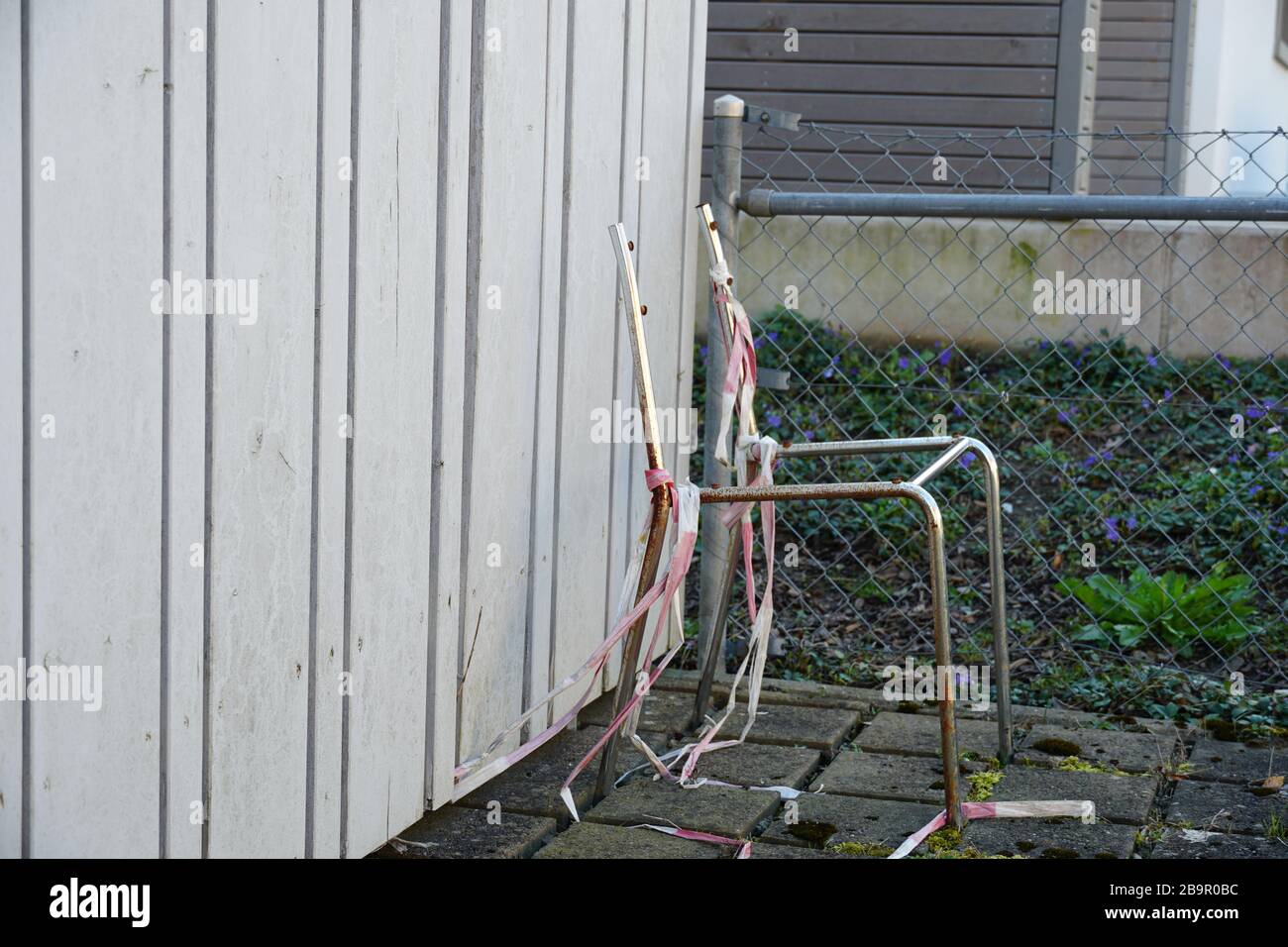 Scheletro o telaio di tubi in metallo lucido in vista laterale avvolto con un vecchio nastro protettivo rosso e bianco per segnalare il pericolo. Foto Stock