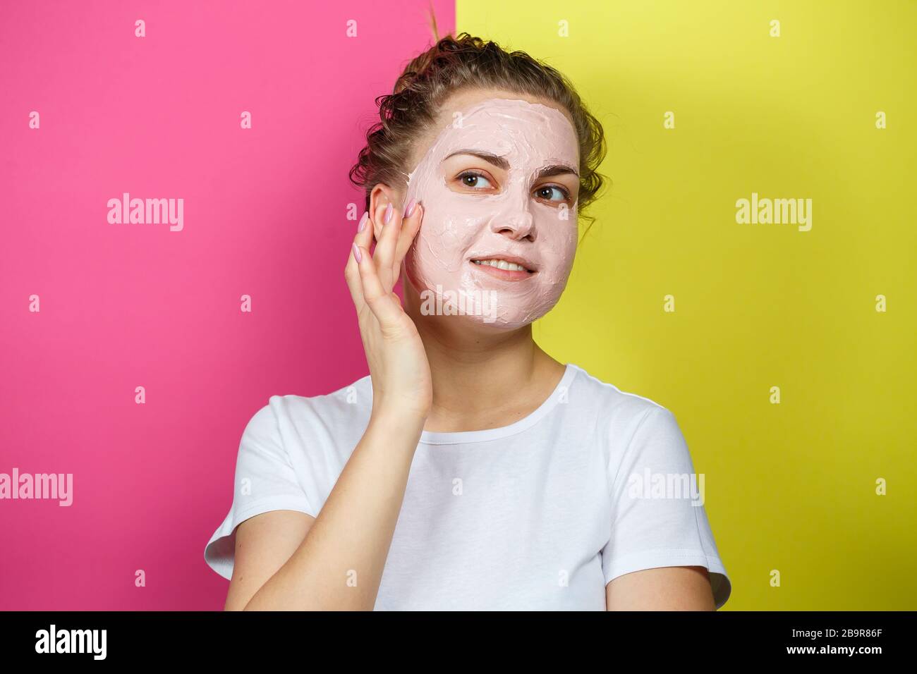 Ritratto di una bella giovane ragazza che mette una maschera rinfrescante sul suo viso per ringiovanire e tonificare la pelle. Trattamenti di bellezza Foto Stock