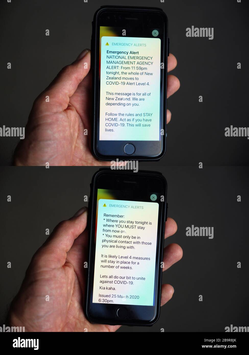 Telefono cellulare con mano che mostra l'avviso di emergenza nazionale neozelandese relativo a un blocco a livello nazionale dovuto a coronavirus COVID-19 Foto Stock
