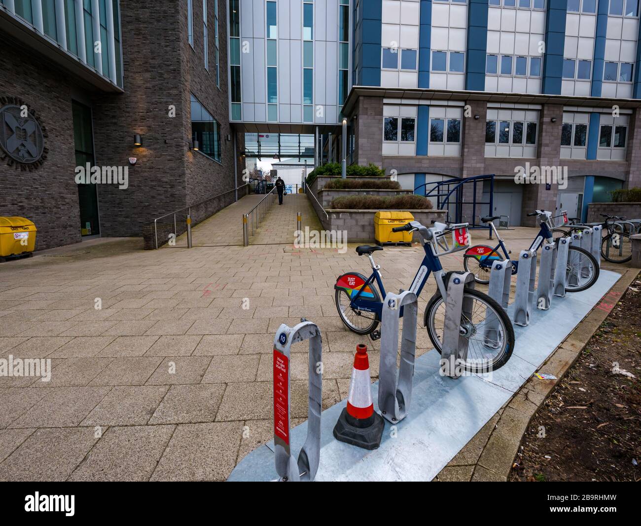 Edimburgo, Scozia, Regno Unito, 25 marzo 2020. Just Eat Bikes annuncia l'uso gratuito di biciclette elettriche per il personale NHS e un aumento della fornitura in alcuni ospedali, tra cui il generale occidentale qui. Lo schema elettrico è stato lanciato all'inizio di questo mese. All'inizio della giornata lavorativa, nel parco si trovano solo due biciclette Foto Stock