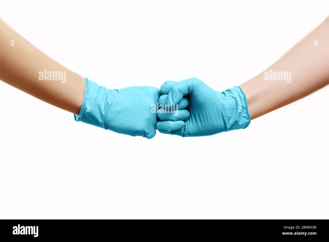 Mani di amici in guanti medici si salutano l'un l'altro con il primo urto isolato su sfondo bianco. Foto Stock