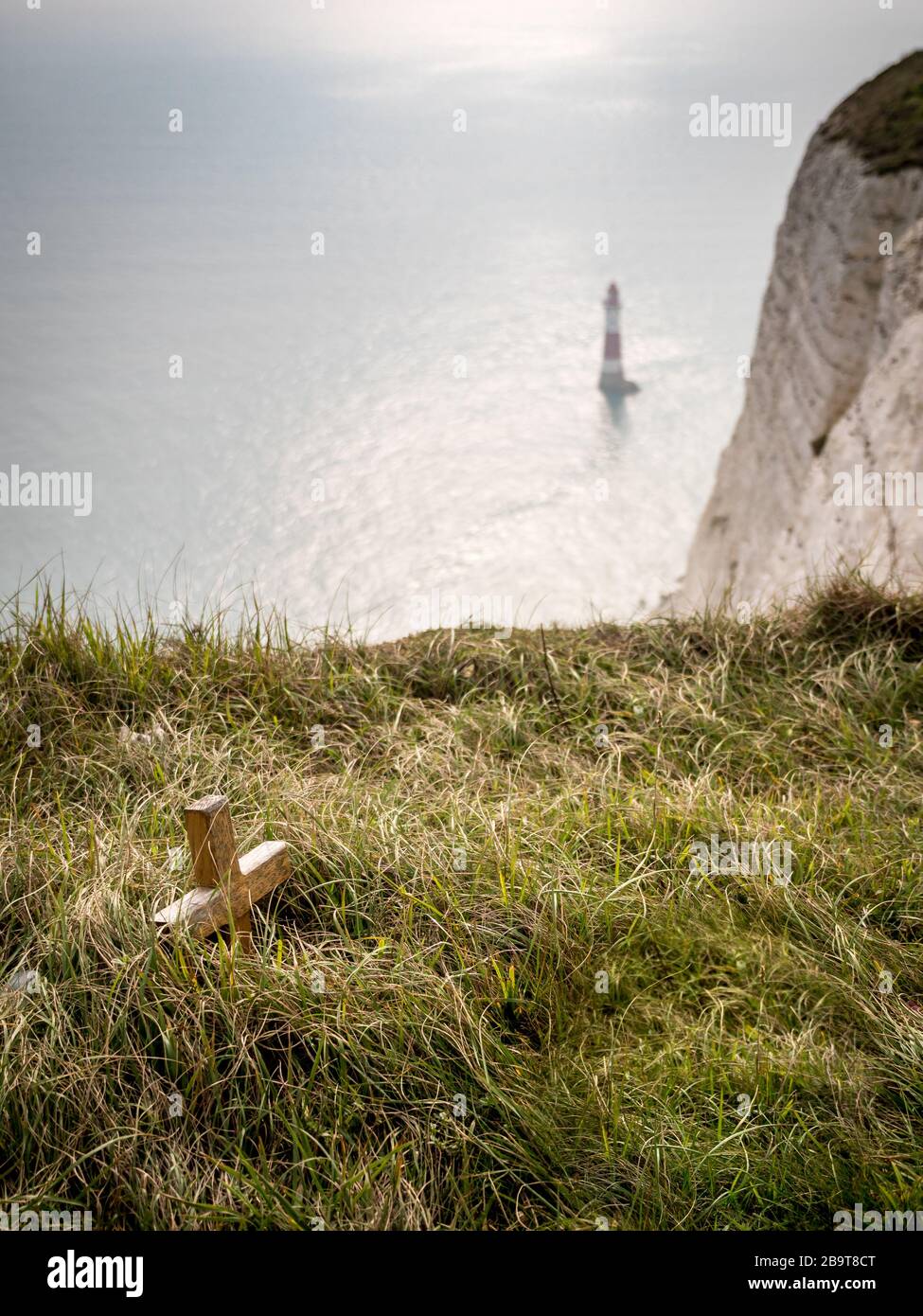 Beachy Head, faro e memoriale. Focus su un piccolo crocifisso di legno posto in memoria di qualcuno che è caduto vittima del famigerato luogo suicida. Foto Stock