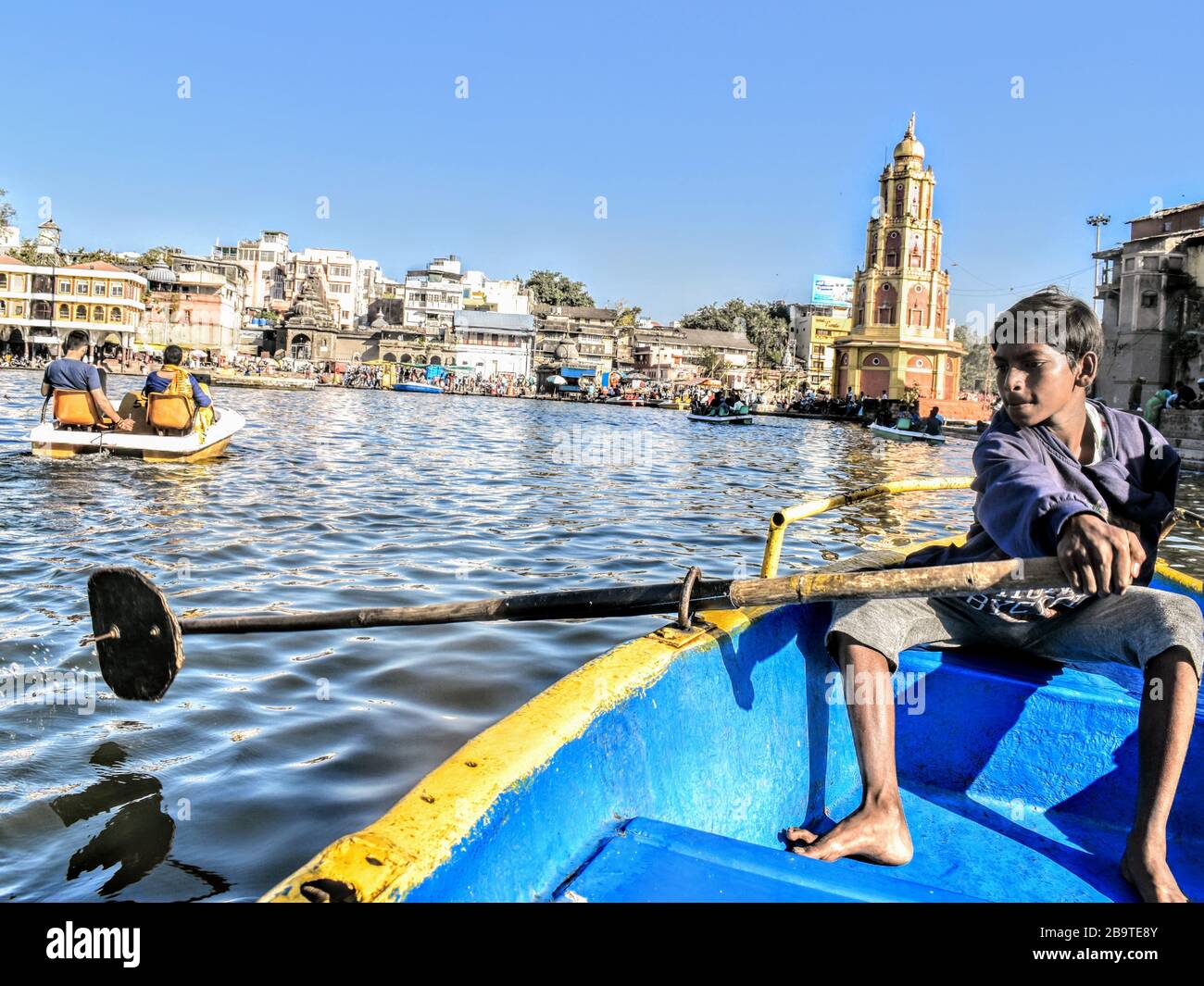 Un ragazzo a mano che voga turisti su una barca a Nashik, India Foto Stock