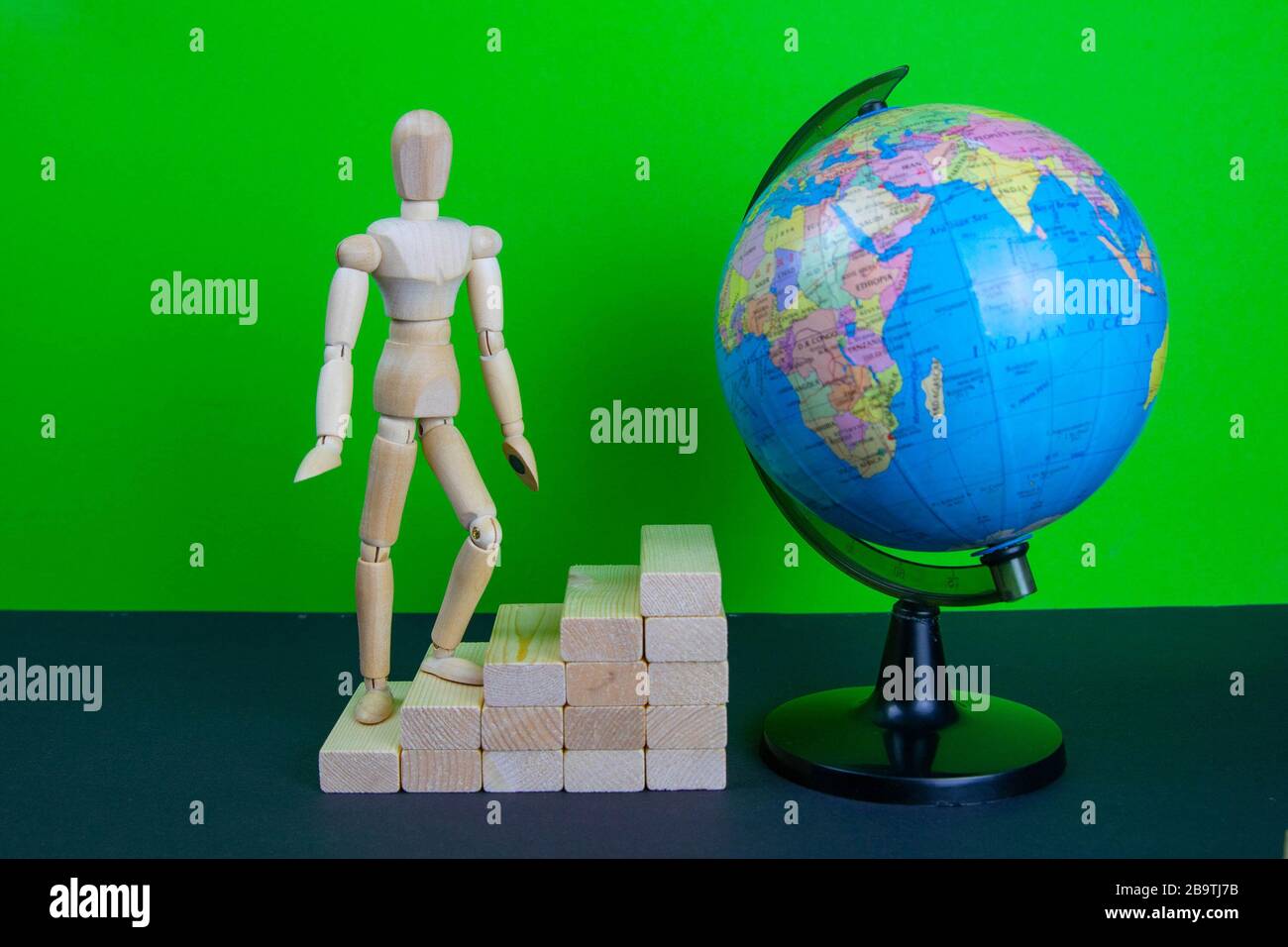 Uomo di legno che cammina sulla scala di carriera. Le scale sono realizzate in mattoni di legno. Manichino in cima allo sviluppo. Il concetto di sviluppo personale, carriera Foto Stock