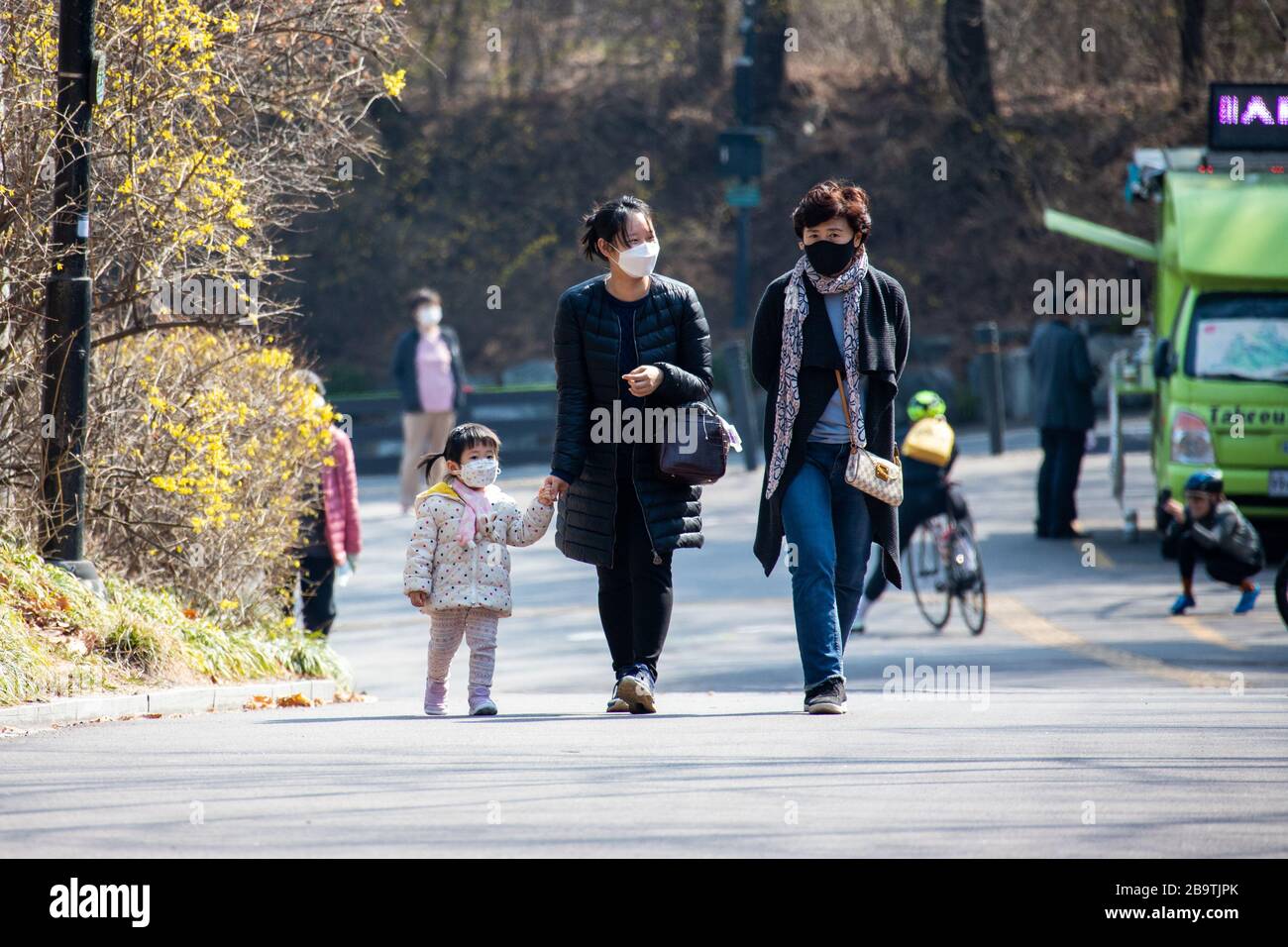 Giovane ragazza e genitori che indossano maschere facciali durante la pandemia di Coronavirus, Seoul, Corea del Sud Foto Stock