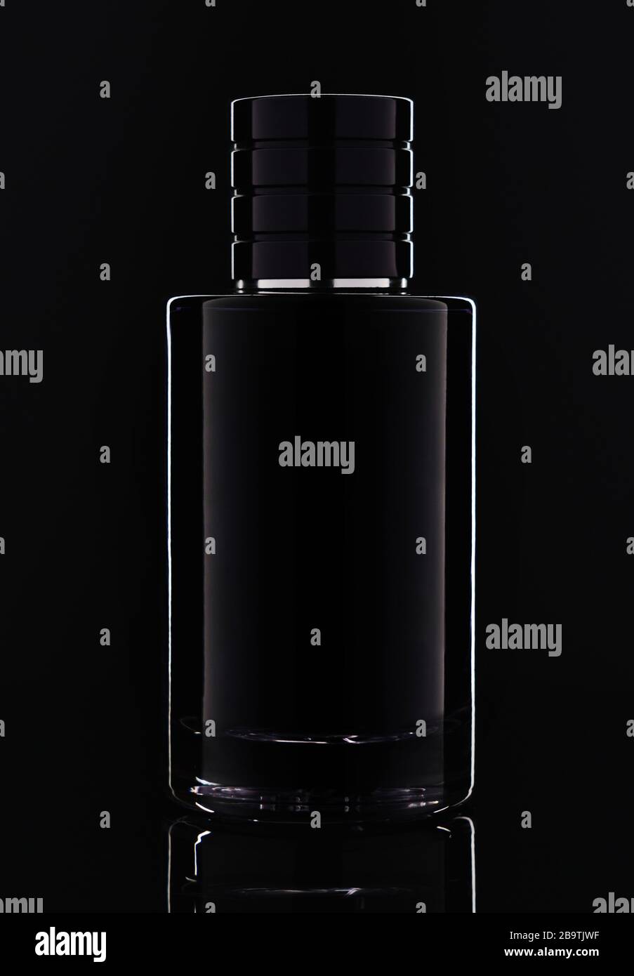 Studio di bottiglia di profumo vetro scuro su sfondo nero con riflessione Foto Stock