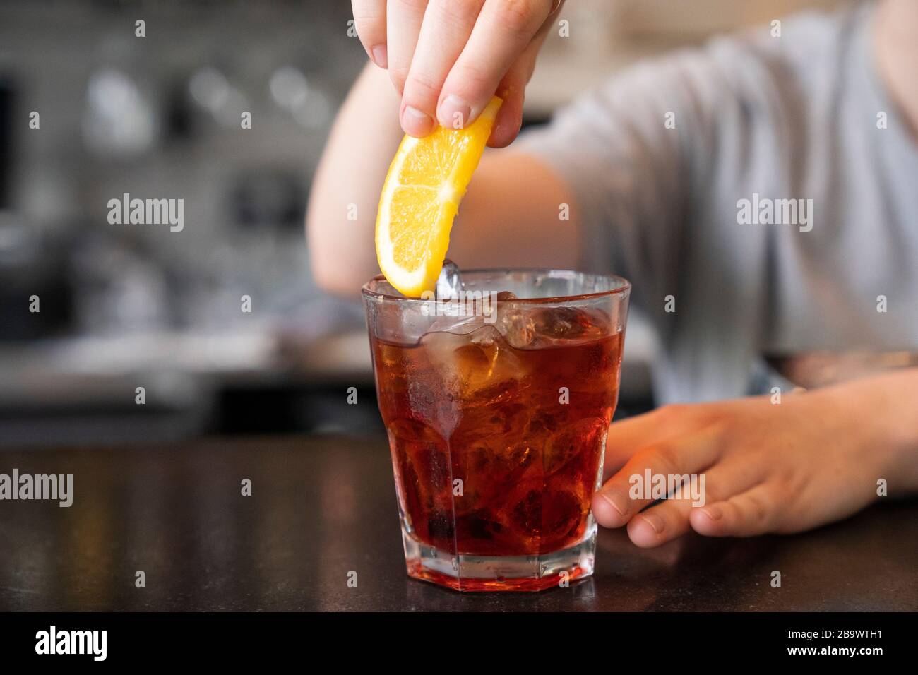 Cocktail vecchio stile nel bar alla moda illuminato dal sole. Foto Stock