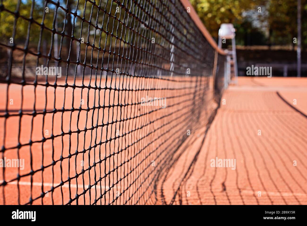 Rete da tennis sul campo esterno. Sfondo sfocato. Tonalità corallo. Illuminazione a mezzogiorno. Foto Stock