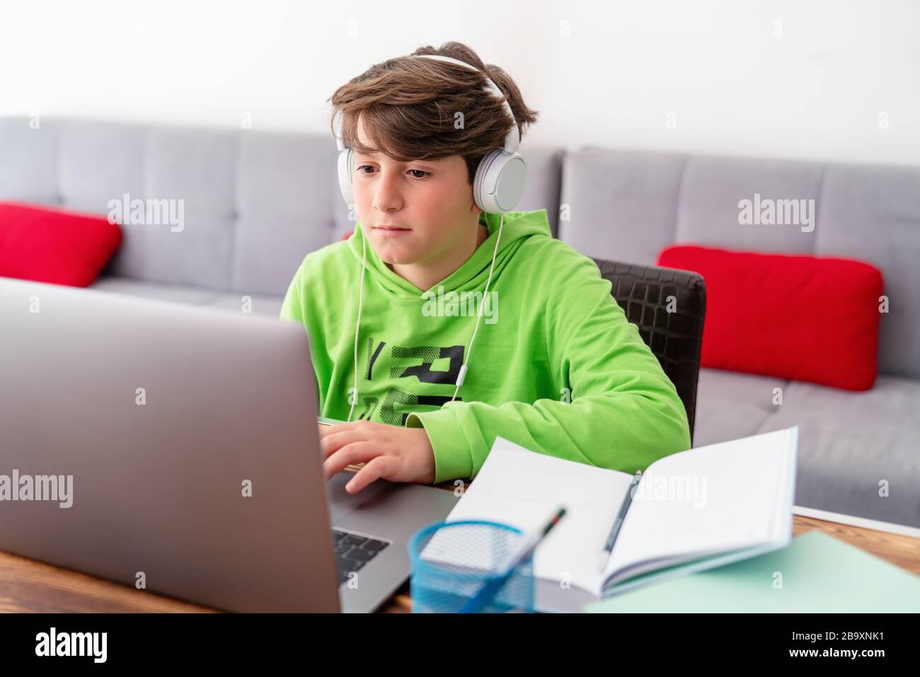 Giovane ragazzo sta studiando di fronte al laptop. E learning, studio a casa online Foto Stock