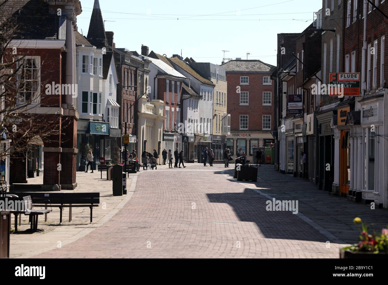 Chichester, Regno Unito. 25 Marzo 2020. Chichester, West Sussex, UK - la High Street è vuota e deserta dopo il blocco dei primi ministri Coronavirus (Covid-19). Le uniche persone sono in coda per la farmacia Boots. Mercoledì 25 Marzo 2020 credito: Sam Stephenson/Alamy Live News Foto Stock