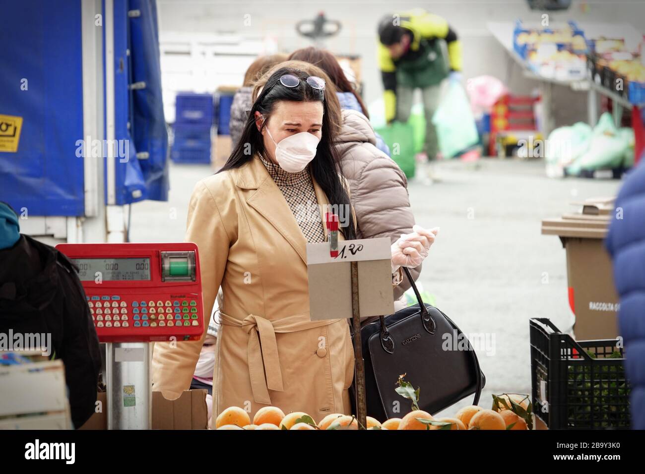 Le persone, con maschere facciali per la protezione da COVID-19, stanno acquistando verdure e frutta sul mercato. Torino, Italia - Marzo 2020 Foto Stock