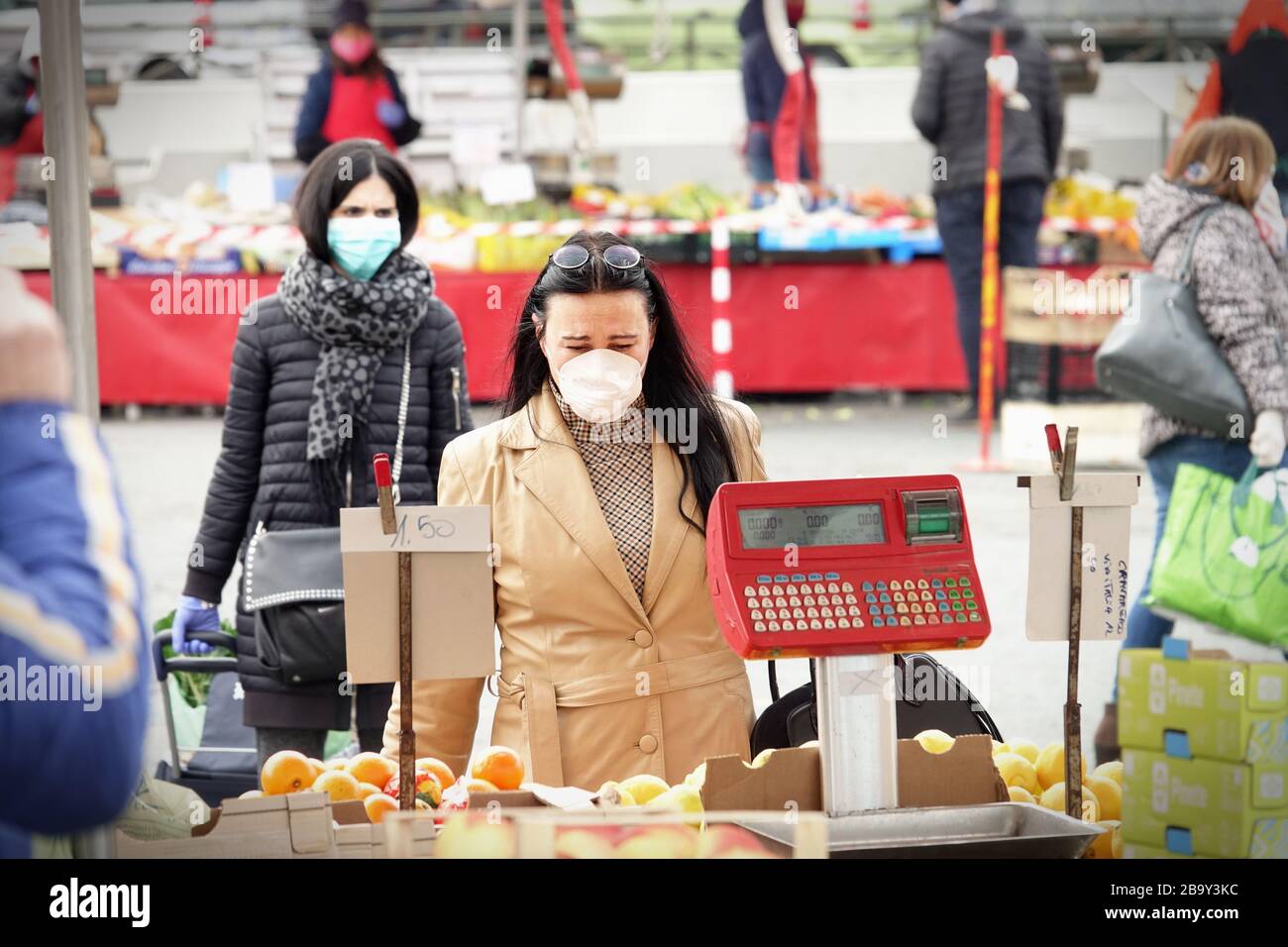Le persone, con maschere facciali per la protezione da COVID-19, stanno acquistando verdure e frutta sul mercato. Torino, Italia - Marzo 2020 Foto Stock