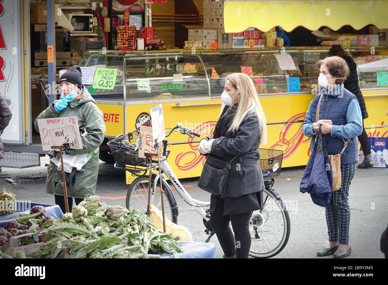 Le persone, con maschere facciali per la protezione da COVID-19, stanno acquistando verdure e frutta sul mercato. Torino, Italia - Marzo 2020 Foto Stock