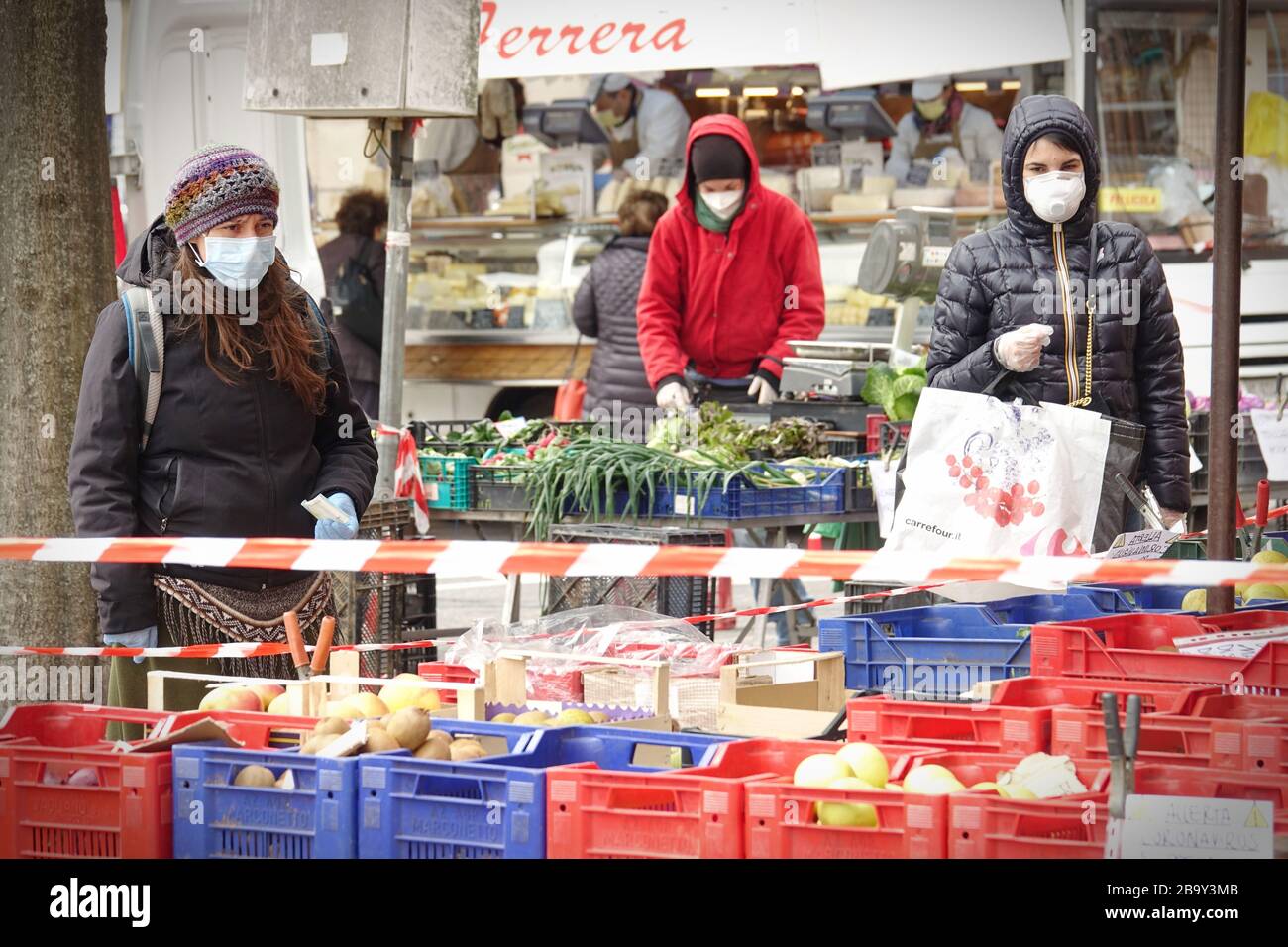 Le persone, con maschere facciali per la protezione da COVID-19, stanno acquistando verdure e frutta sul mercato. Torino, Italia - Marzo 2020 Foto Stock