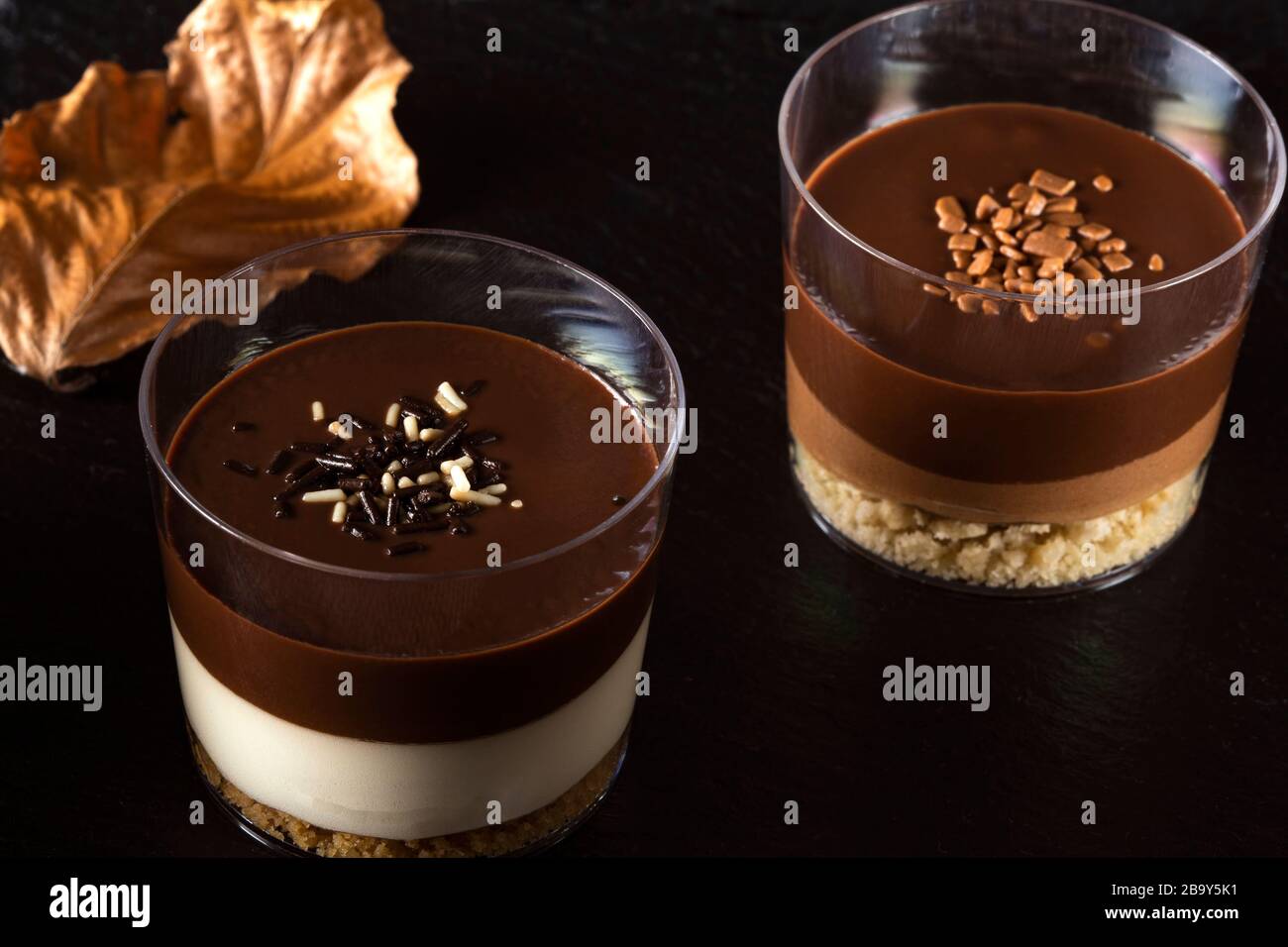 Dessert al cioccolato in bicchieri su ardesia scura Foto Stock