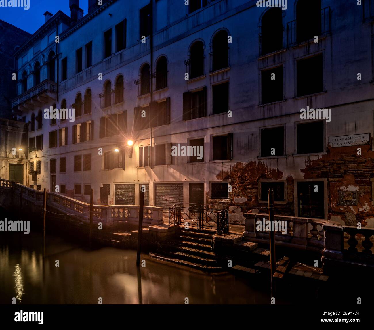Foto notturna di case, strade e canali d'acqua a Venezia Foto Stock