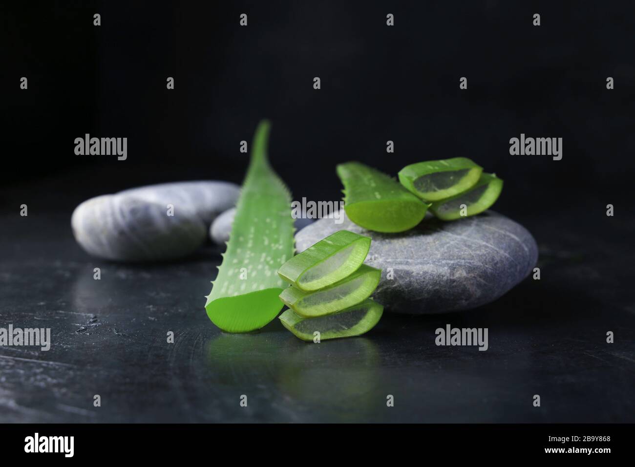 soffiatore di aloe vera fresco con pietre spa su sfondo scuro Foto Stock