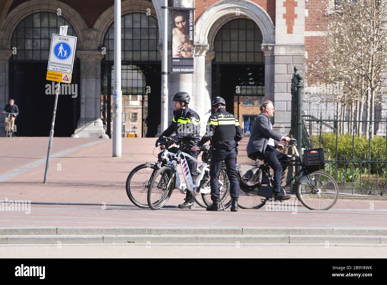 Amsterdam, Paesi Bassi. 25 Marzo 2020. Due poliziotti olandesi pattugliano le persone per praticare le distanze sociali e mantenere 1.5 metri al Museumplein il 25 marzo 2020 ad Amsterdam, Paesi Bassi. Il ministro olandese della giustizia e della sicurezza Ferdinand Grapperhaus ha ordinato nuove misure più severe per combattere la diffusione del coronavirus, nei parchi, nelle strade e negli spazi pubblici, la gente deve praticare il distanziamento sociale e mantenere 1.5 metri, questo per un gruppo di tre o più persone (che non sono familiari), Una multa di 400 euro sarà consegnato.(foto di Paulo Amorim/Sipa USA) credito: Sipa USA/Alamy Live NE Foto Stock