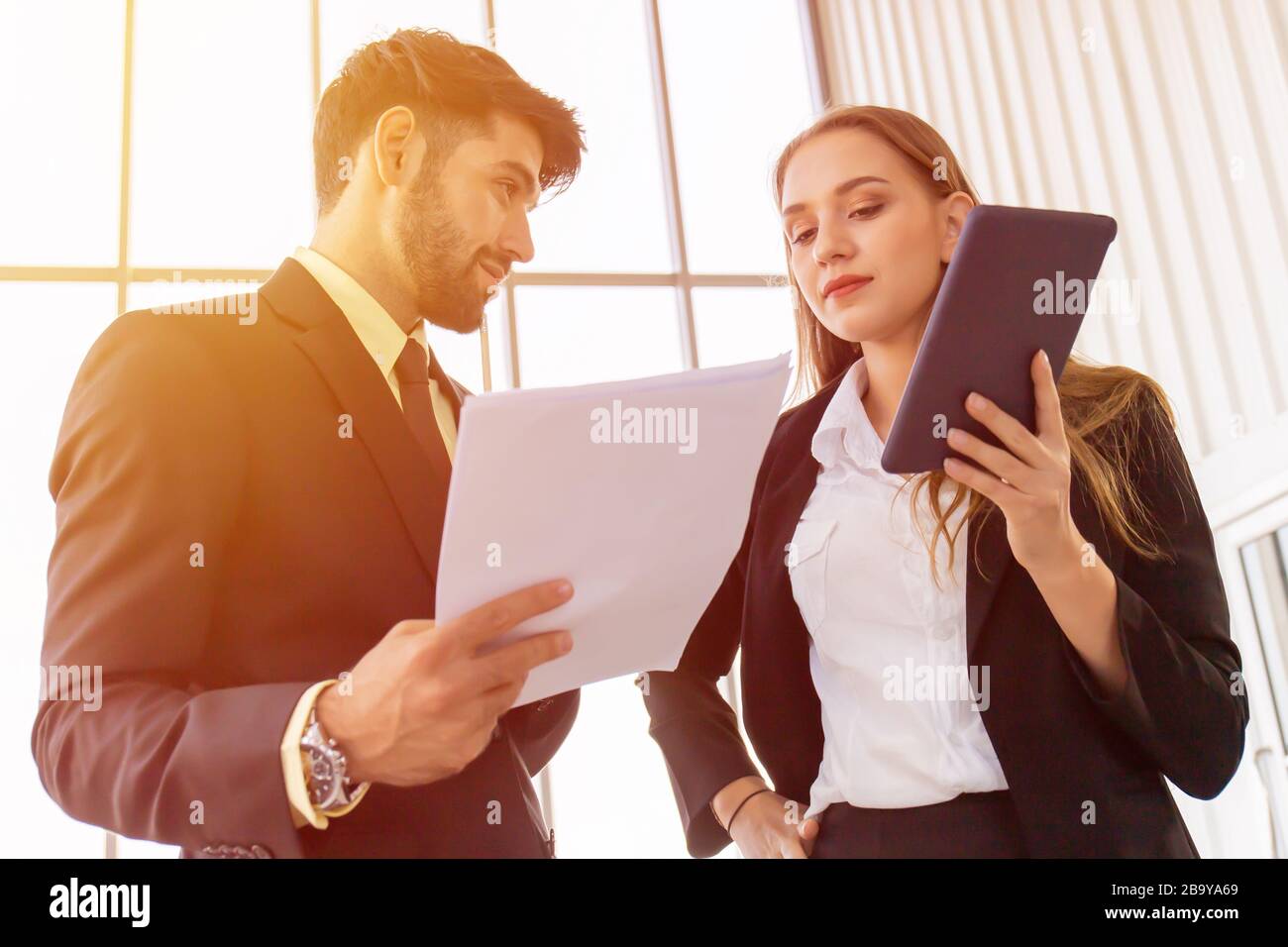 Due uomini d'affari e donne che si riunano in ufficio Foto Stock