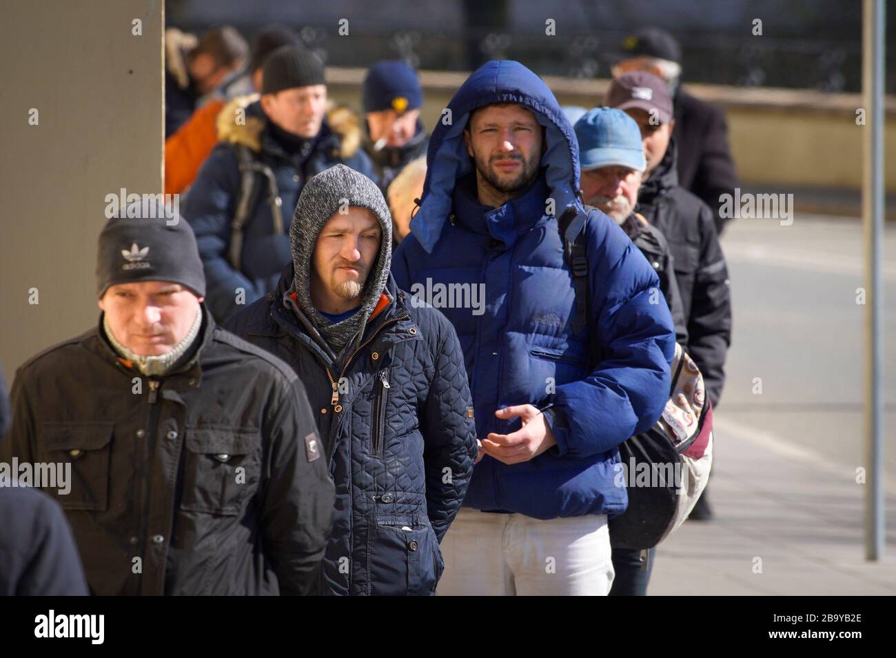 Varsavia, Polonia. 23 marzo 2020. I senzatetto attendono in fila in una chiesa per ricevere un pranzo caldo a Varsavia, Polonia, il 23 marzo 2020. I senzatetto sono uno dei gruppi più vulnerabili al coronavirus a causa della loro incapacità di isolare i desiseases andco-occuring. Gli esperti sanitari americani e canadesi hanno avvertito che le città con grandi popolazioni di senzatetto soffriranno di una diffusione più rapida del virus. (Foto di Jaap Arriens/Sipa USA) Credit: Sipa USA/Alamy Live News Foto Stock