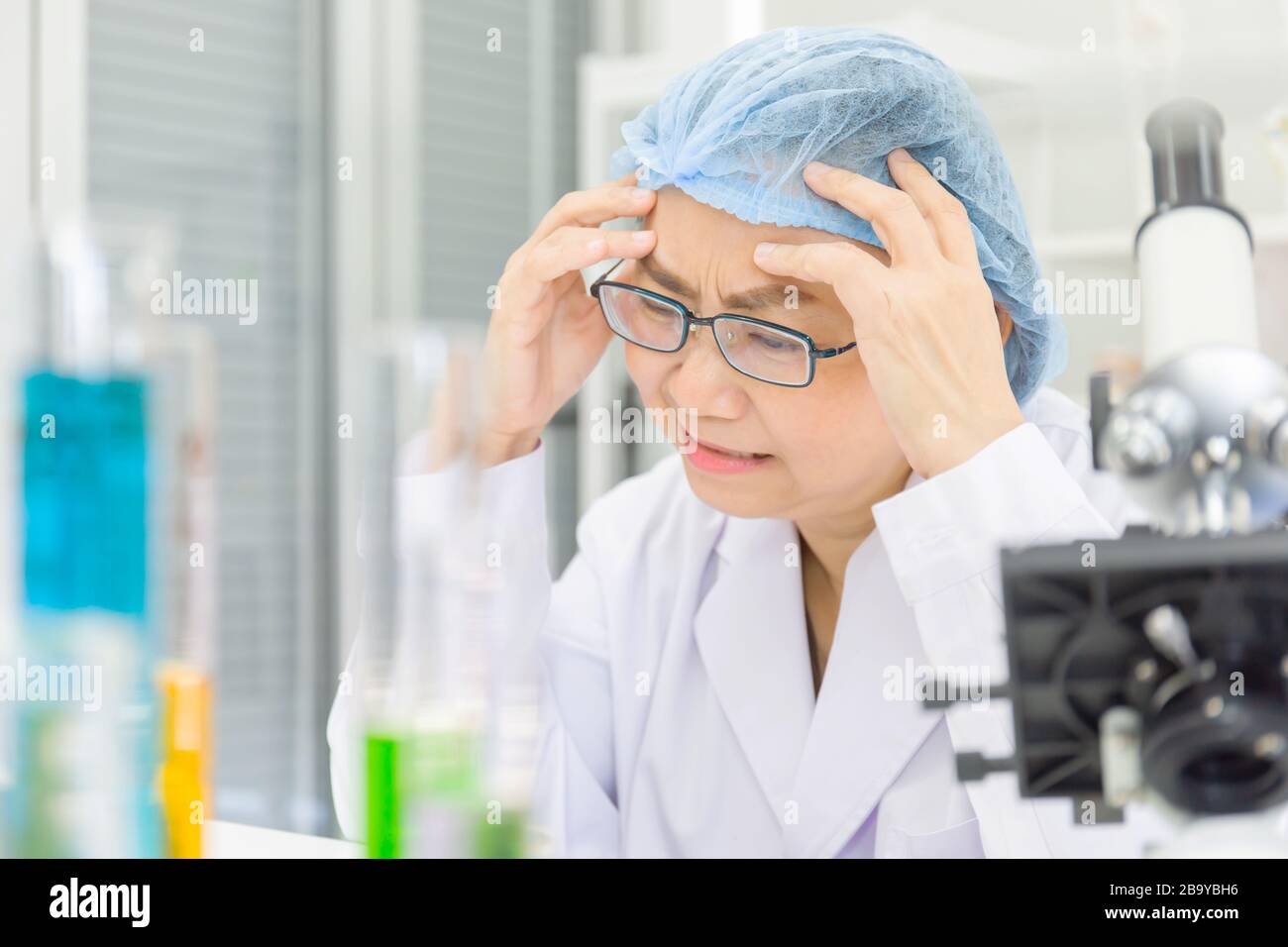Le scienziati asiatiche femminili stanno ricercando le formule chimiche nei laboratori con lo sforzo. Foto Stock