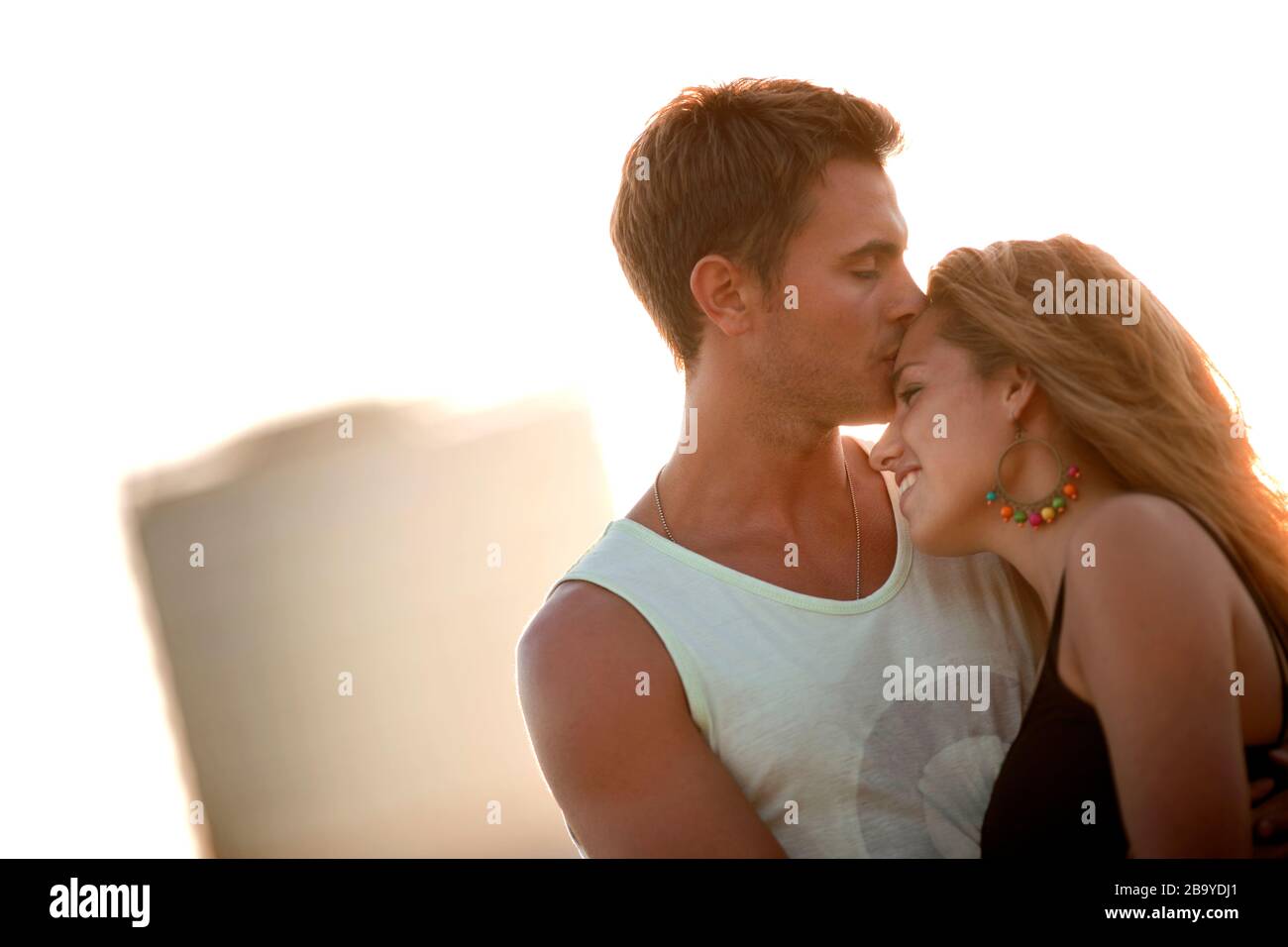 Giovane uomo bacia la sua ragazza sulla fronte. Foto Stock