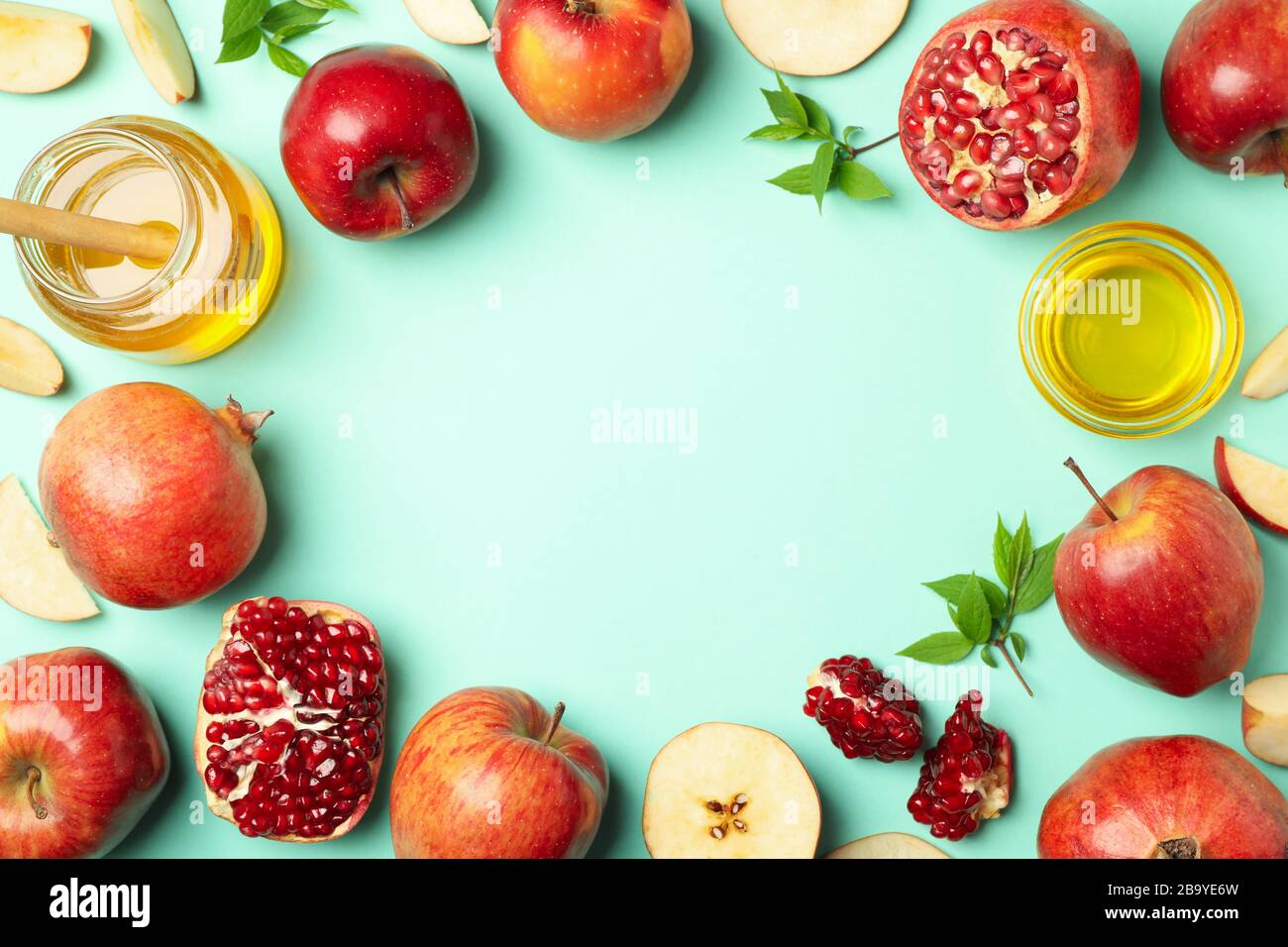 Mela, miele e melograno su fondo menta, spazio per il testo Foto Stock