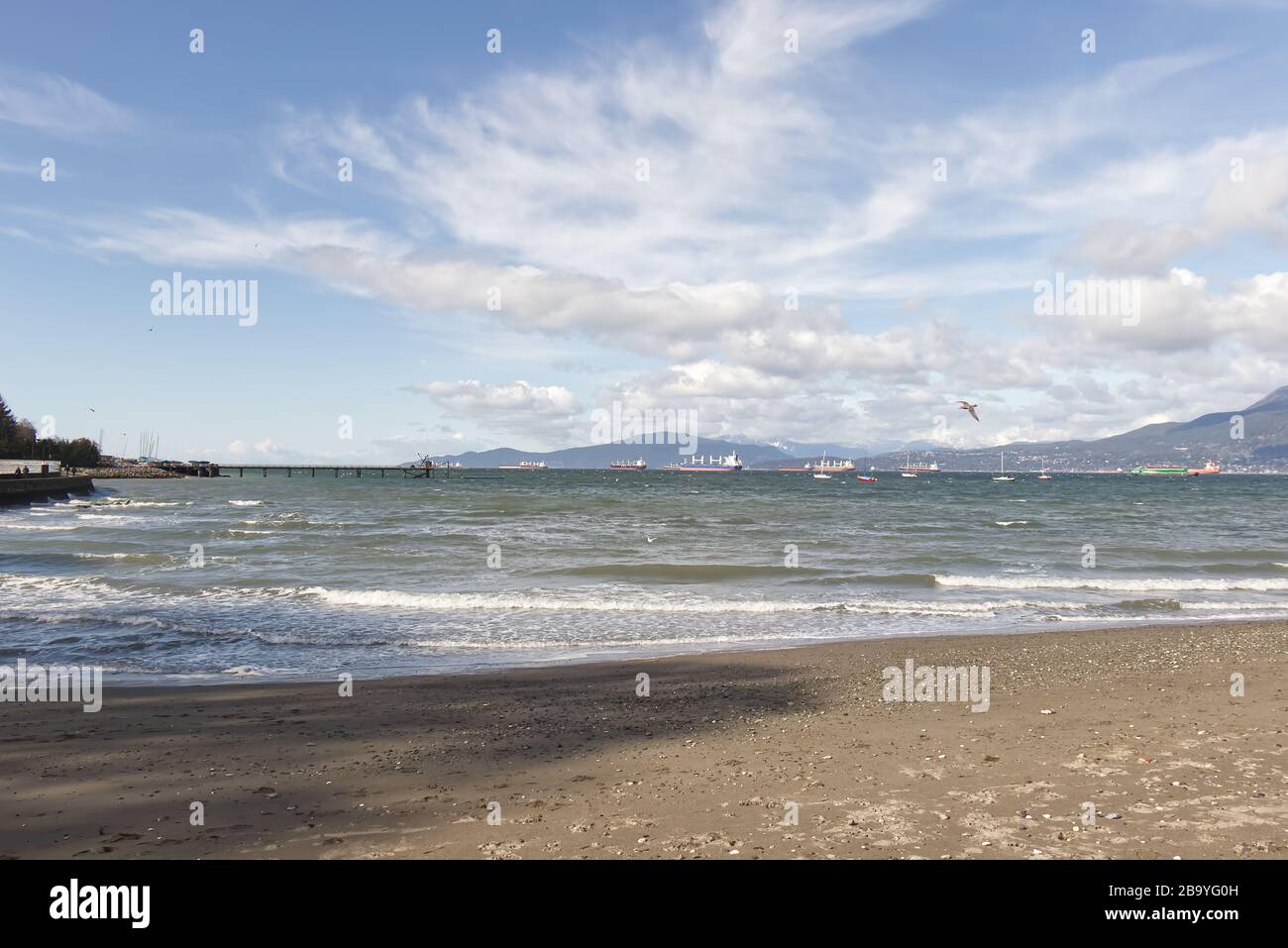 Spiaggia di Kitsilano in una giornata di sole a Vancouver con montagne sullo sfondo durante la stagione invernale Foto Stock