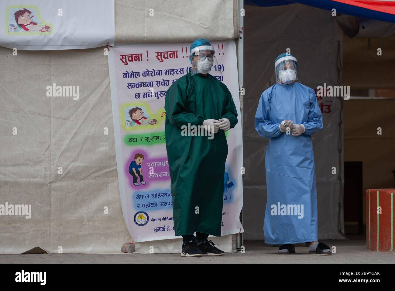 I funzionari medici in dispositivi di protezione si trovano accanto a una tenda di pre-esame designata per un rapido controllo sanitario presso il Nepal Medical College Hospital durante l'epidemia di virus corona Threats.Nepal ha segnalato il terzo caso positivo del virus corona. Foto Stock