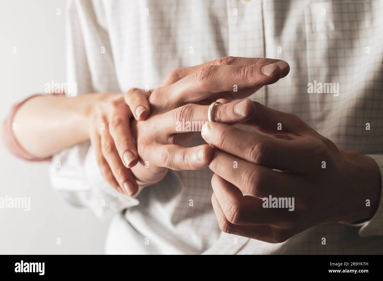 Un uomo rimuove un anello di nozze dal dito. Il marito sta truffando sua moglie. Il concetto di tradimento. Foto Stock