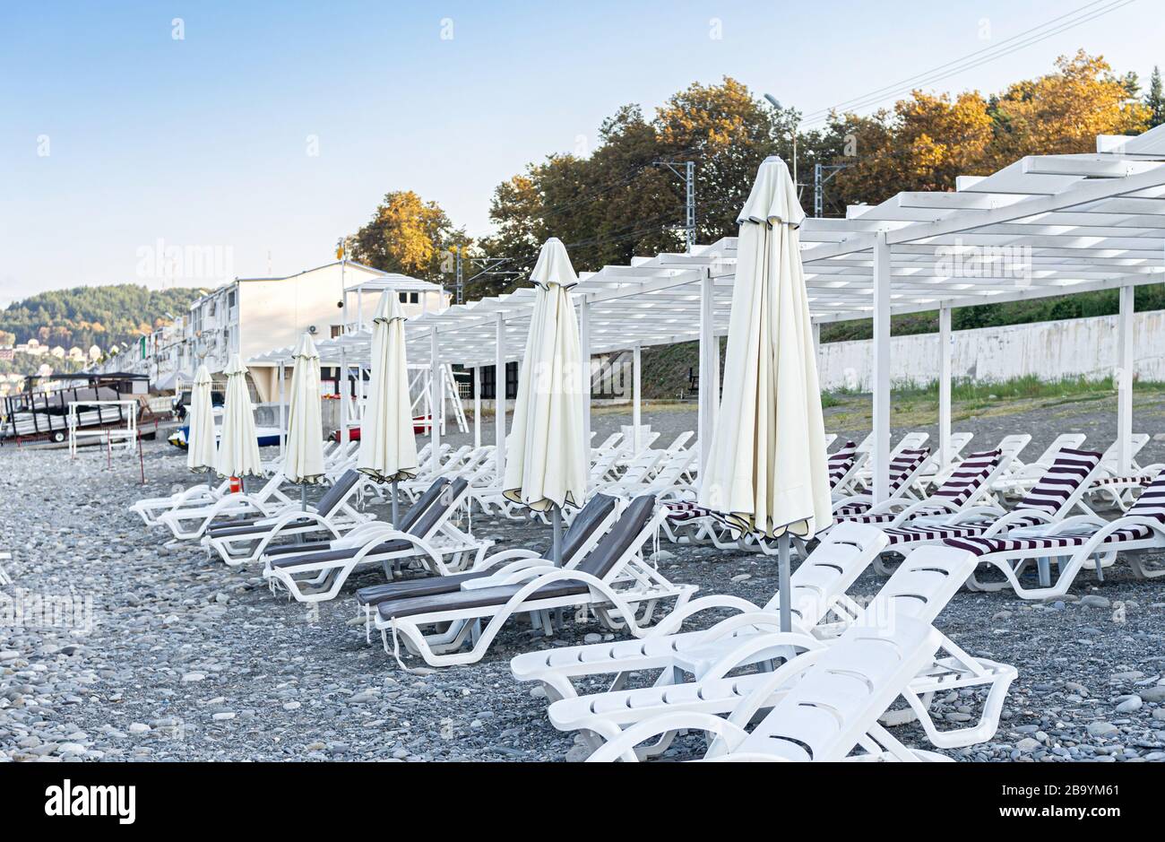 Spiaggia vuota con lettini e ombrelloni chiusi durante lo scoppio del virus Covid 19. Concetto di quarantena. La crisi del turismo. Foto Stock