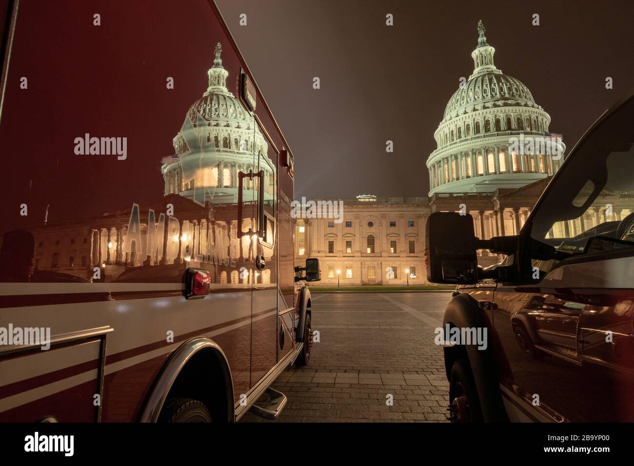 Cupola edificio Capitol riflessione su un'ambulanza rossa. Una perfetta illustrazione dei giorni in cui viviamo con l'arrivo della pandemia di COVID-19. Foto Stock