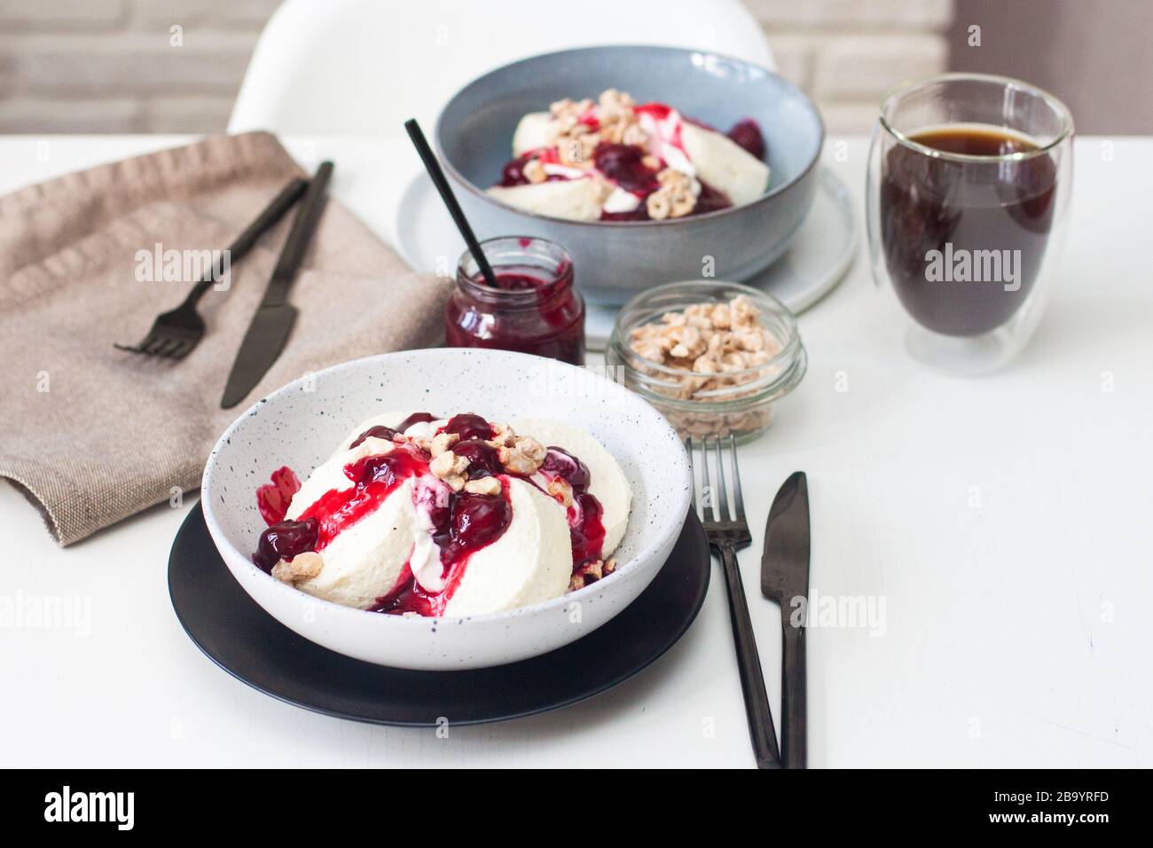 Pancake al formaggio casolare con salsa di ciliegia, panna acida e noci caramellate. Foto Stock