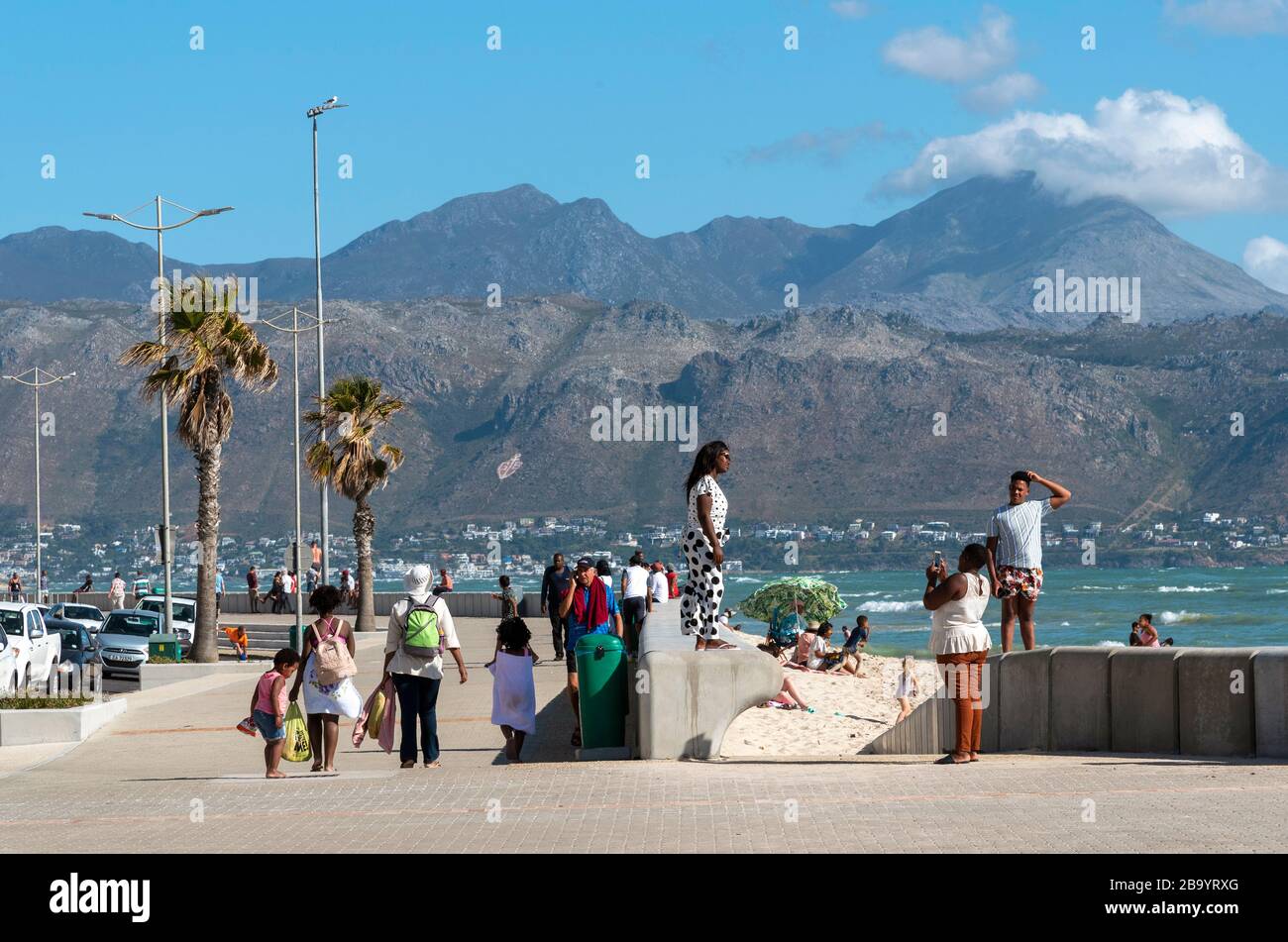 Strand, Somerset West, Western Cape, Sud Africa. Dic 2019. I turisti camminano lungo il lungomare in direzione di Gordon's Bay e Hottentot Holl Foto Stock