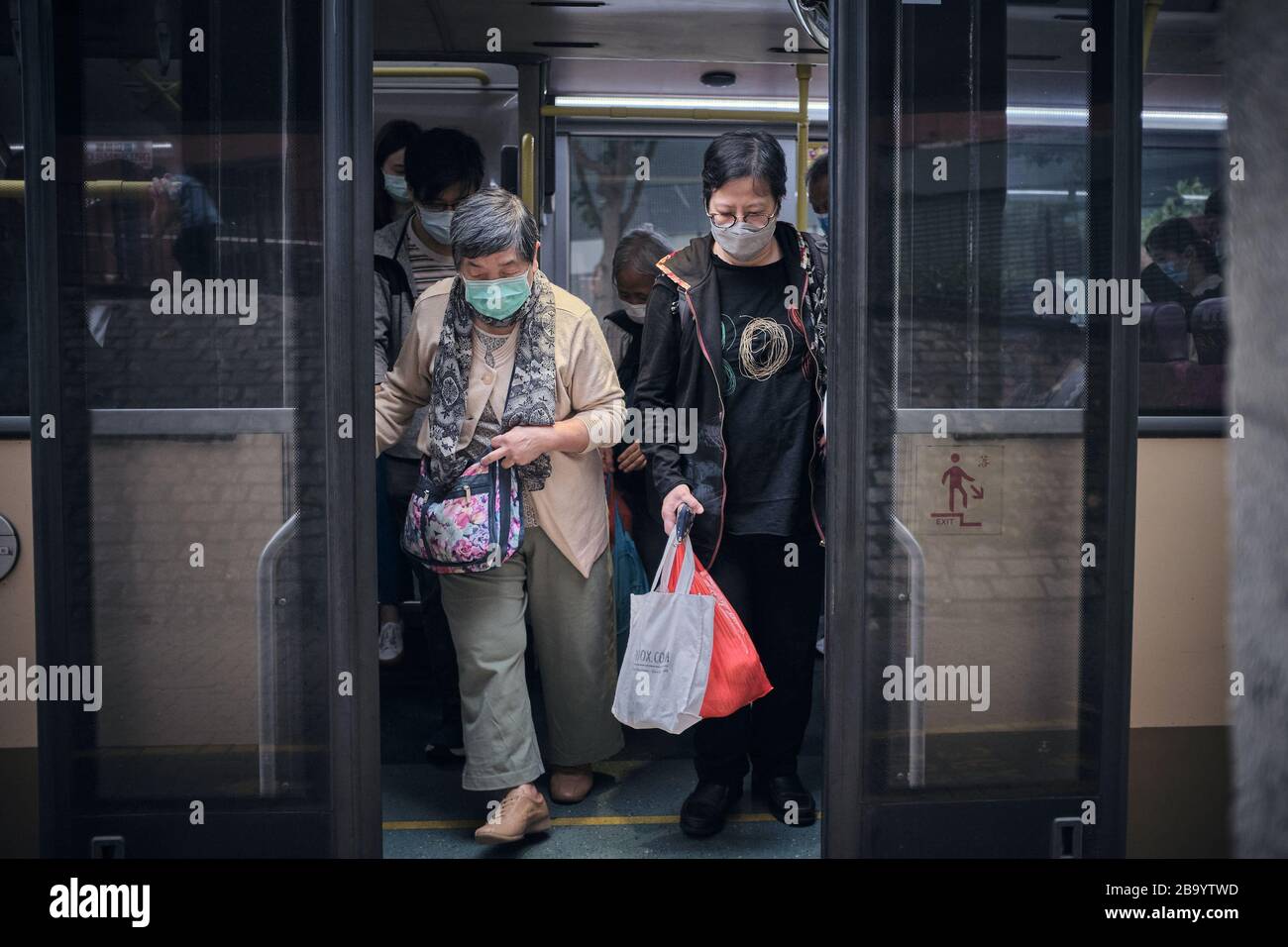 Una donna anziana che viaggia su un autobus indossando una maschera facciale come misura preventiva durante la pandemia del virus della corona. Hong Kong ha finora riferito un totale di 410 casi confermati di coronavirus COVID-19 e 4 persone sono morte di conseguenza. Foto Stock