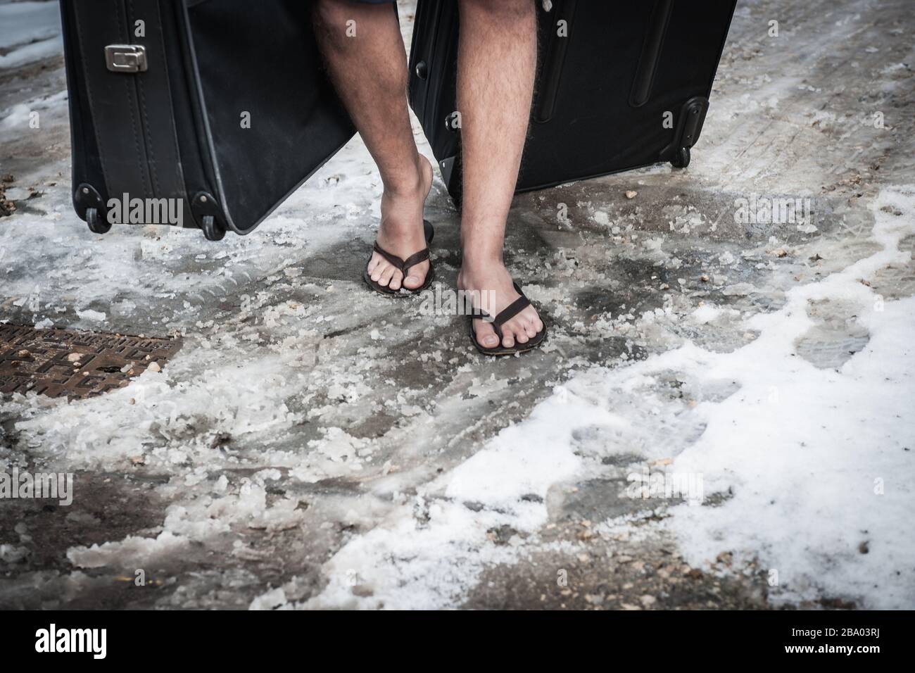 Uomo che cammina con valigia con infradito nella neve invernale Foto stock  - Alamy