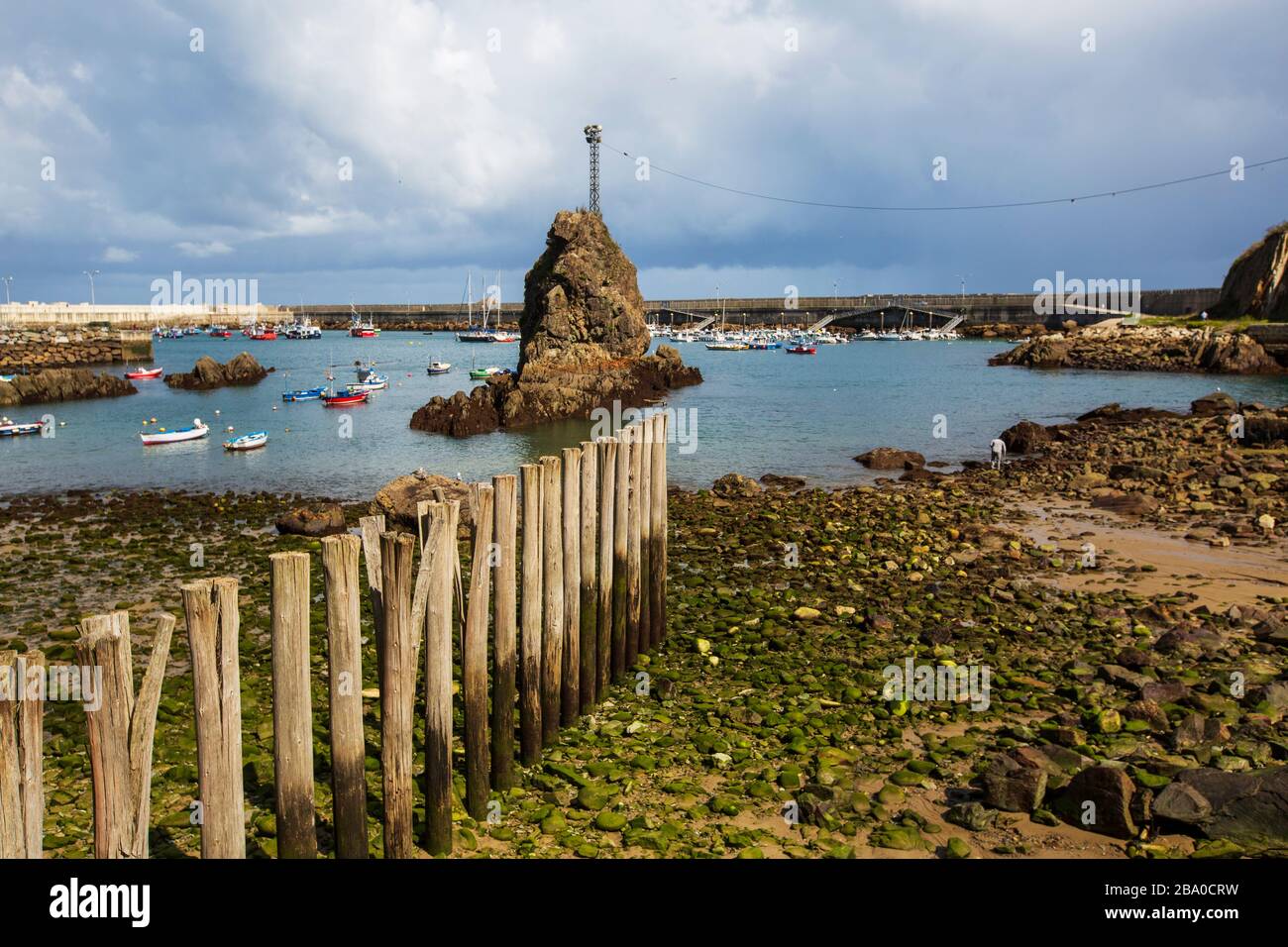 fotografia del mare basso nelle asturie con barche da pesca sullo sfondo Foto Stock