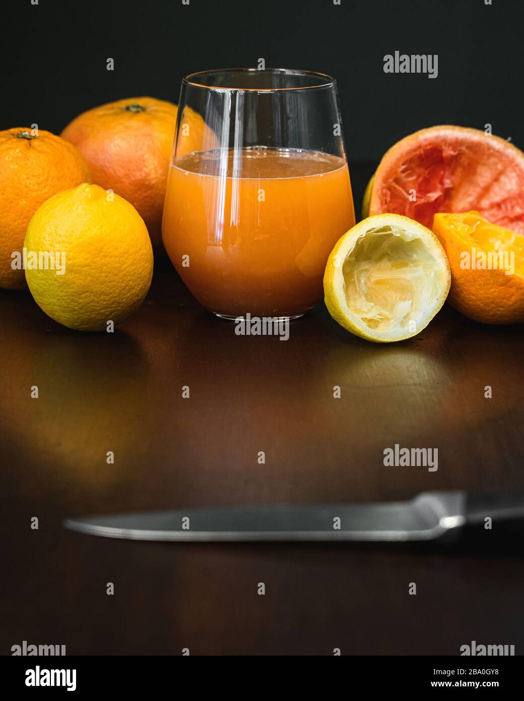 Un bicchiere di succo di frutta appena spremuto e arancia fresca al limone e pompelmo Foto Stock