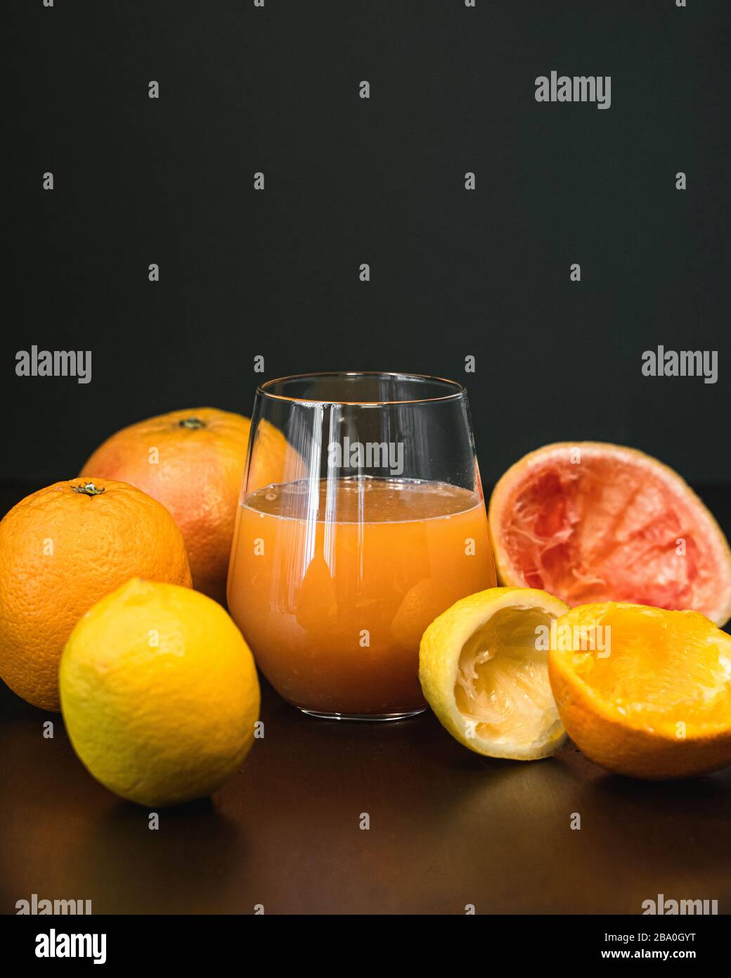 Un bicchiere di succo di frutta appena spremuto e arancia fresca al limone e pompelmo Foto Stock